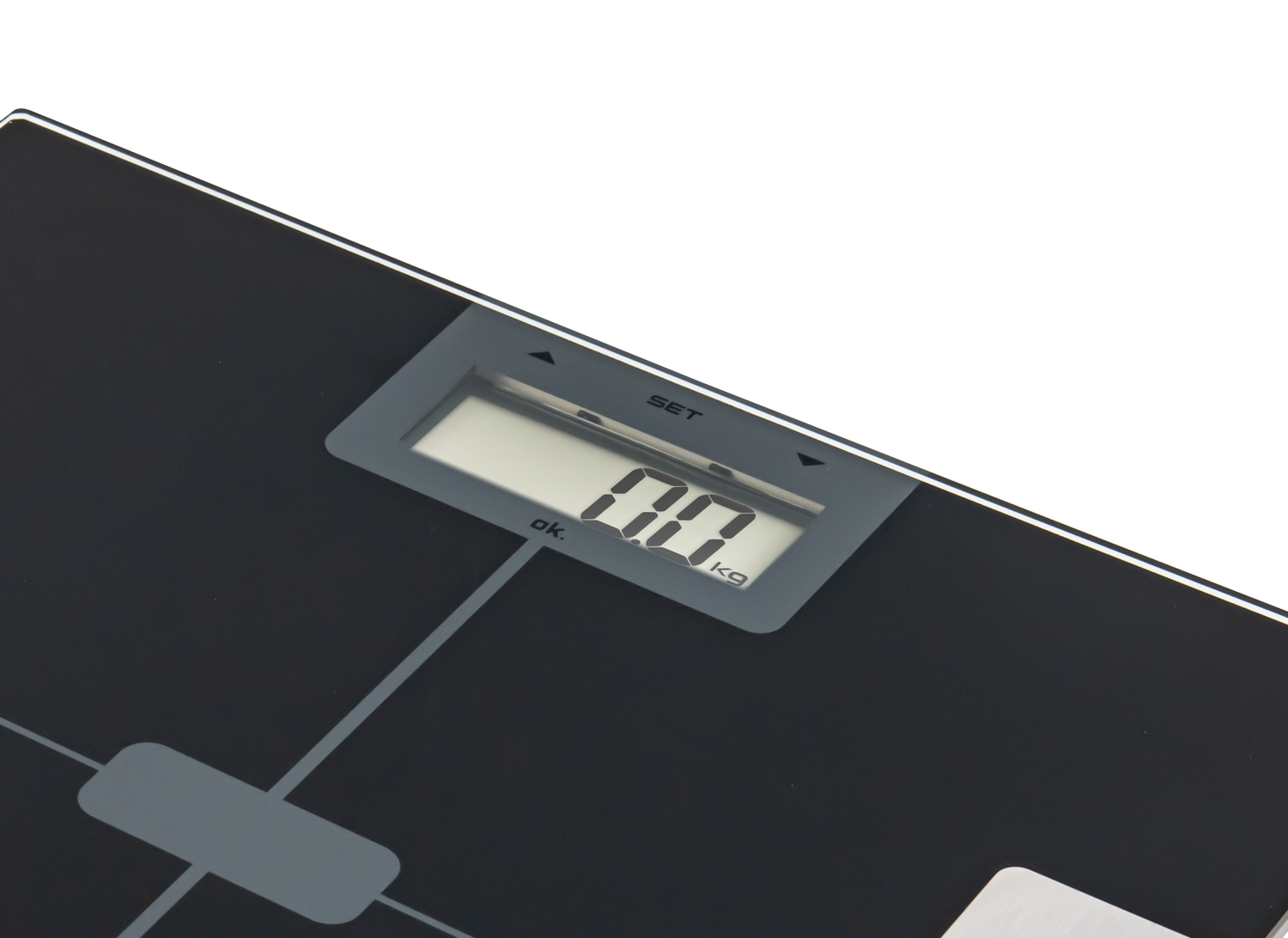 Báscula de baño digital negra con pantalla que muestra '00 kg'. Botones grises y superficie blanca.