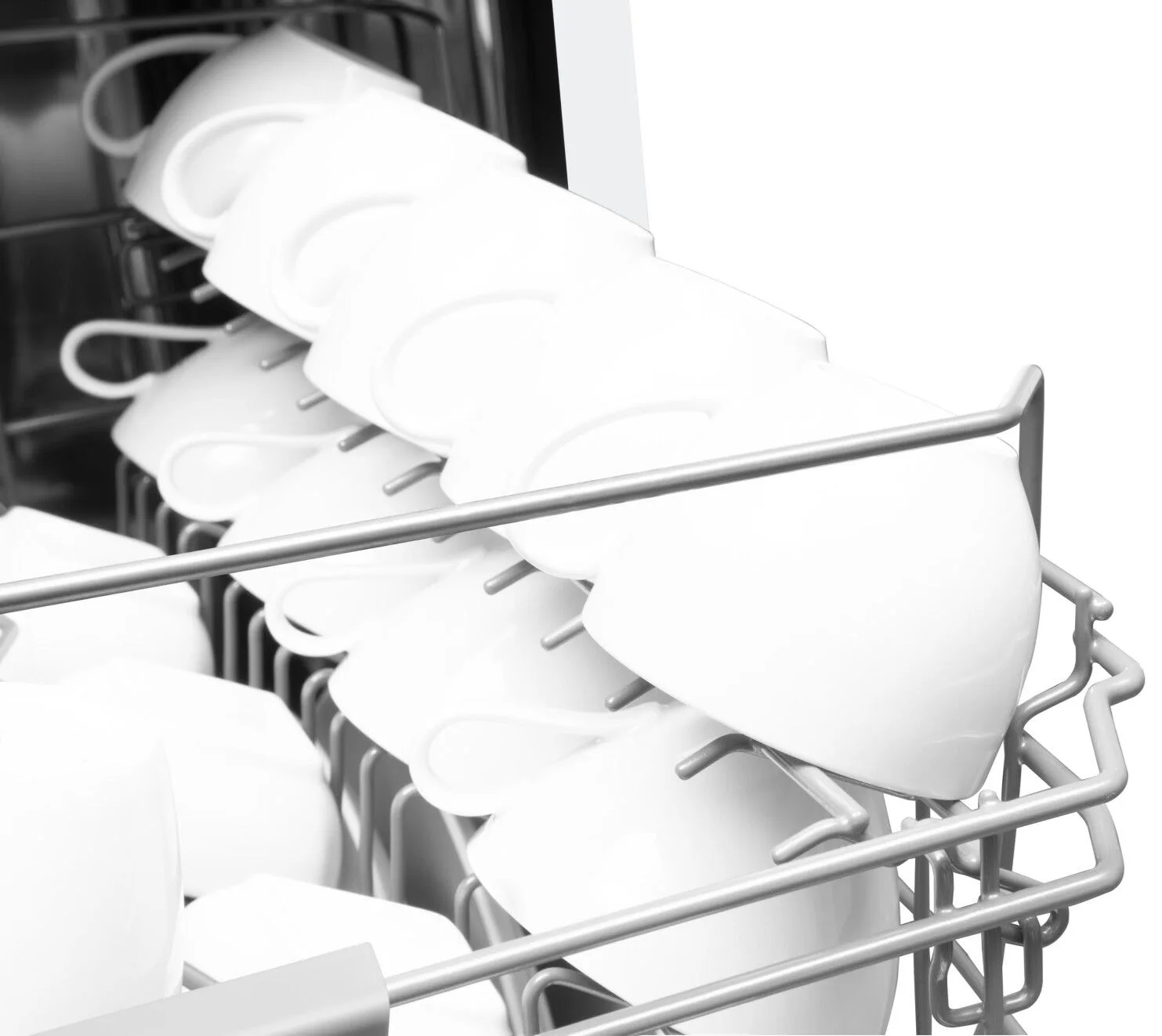 Widok wewnątrz zmywarki. Białe filiżanki są załadowane do górnego kosza.