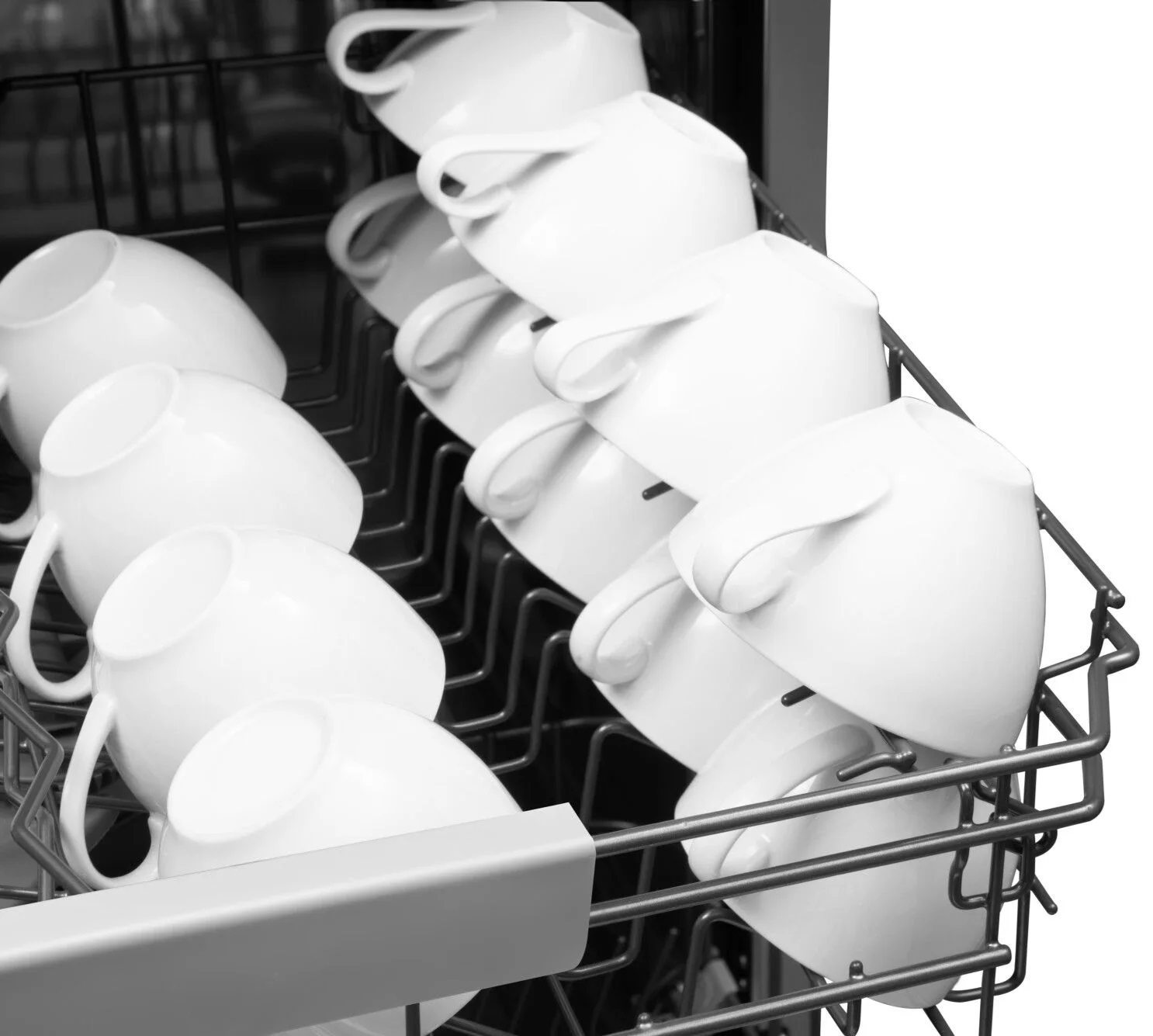 Regał zmywarki z białymi kubkami, obraz czarno-biały.