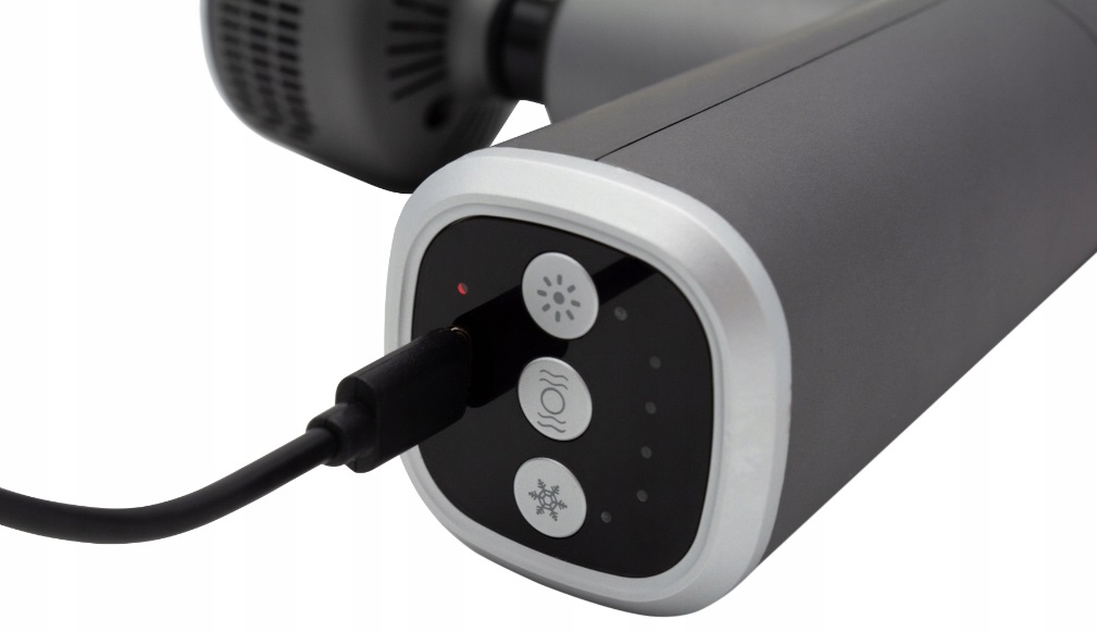 Zbliżenie szarego pistoletu do masażu z czarnym kablem ładującym. Widoczne są przyciski z symbolami.