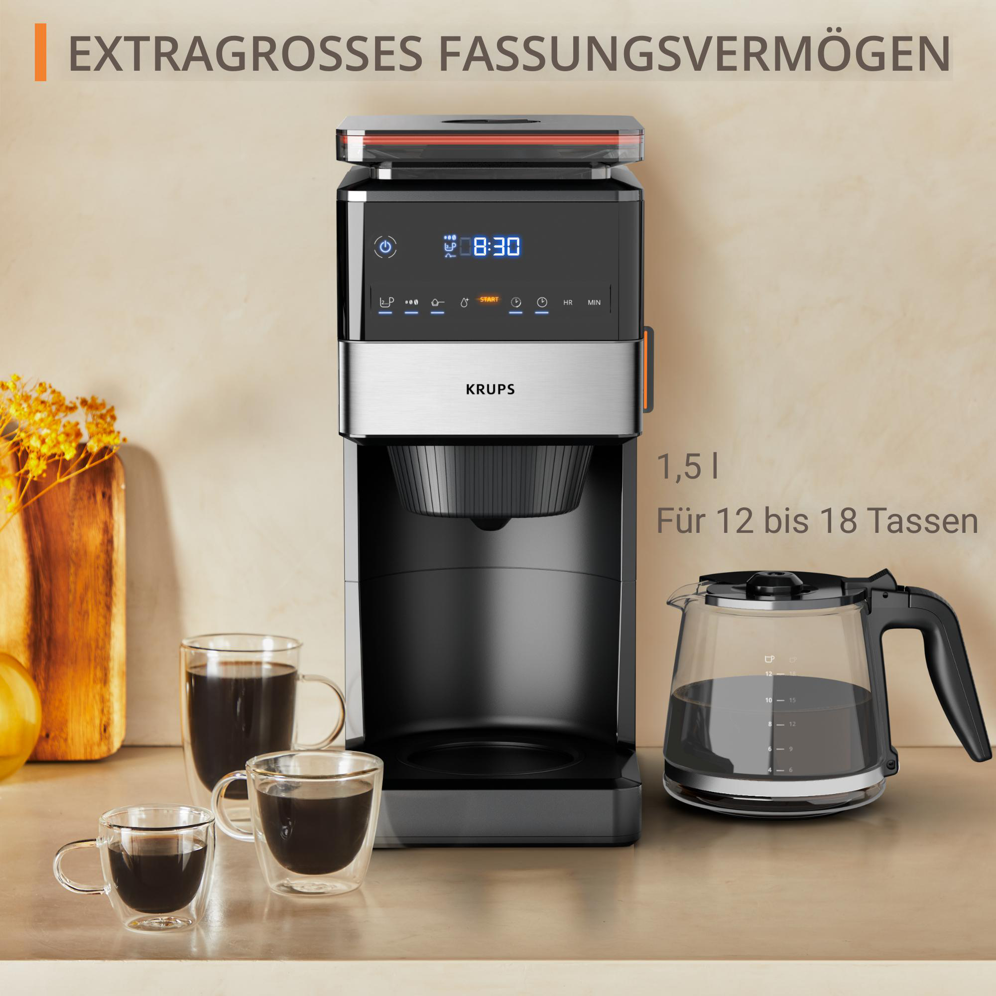 Eine Kaffeemaschine mit Glaskaraffe und zwei Kaffeetassen auf der Theke.