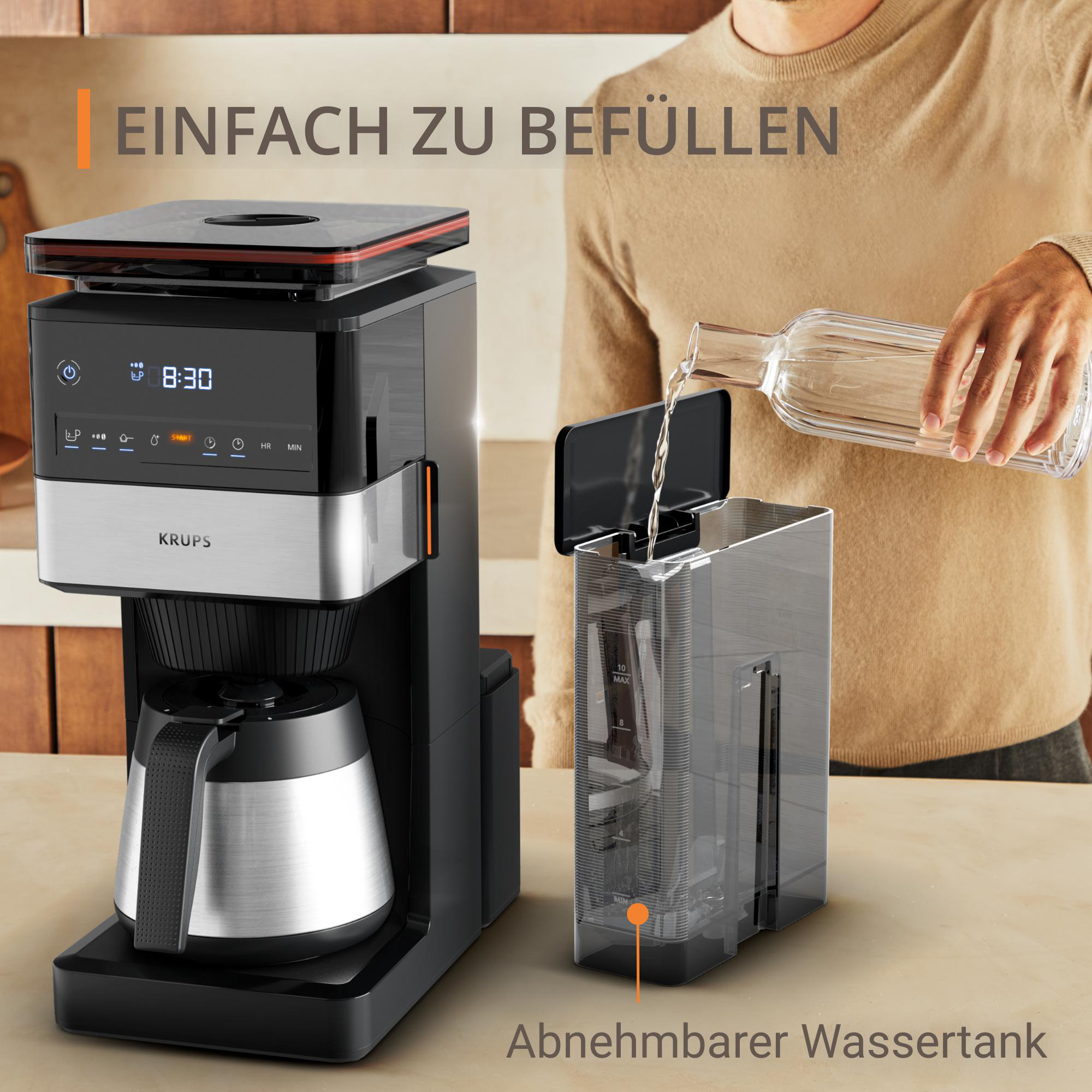 Mann gießt Wasser in den abnehmbaren Wassertank der Kaffeemaschine. Die Maschine ist schwarz und silber.