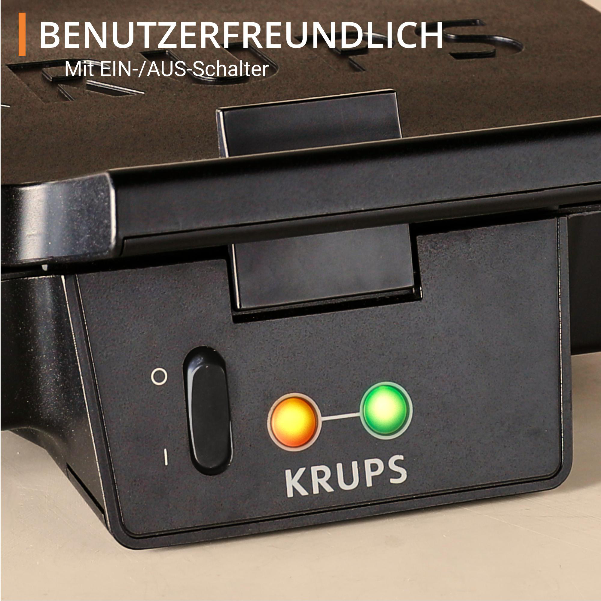 Nahaufnahme des Bedienfelds eines Krups Waffeleisens mit Ein-/Ausschalter und Kontrollleuchten.