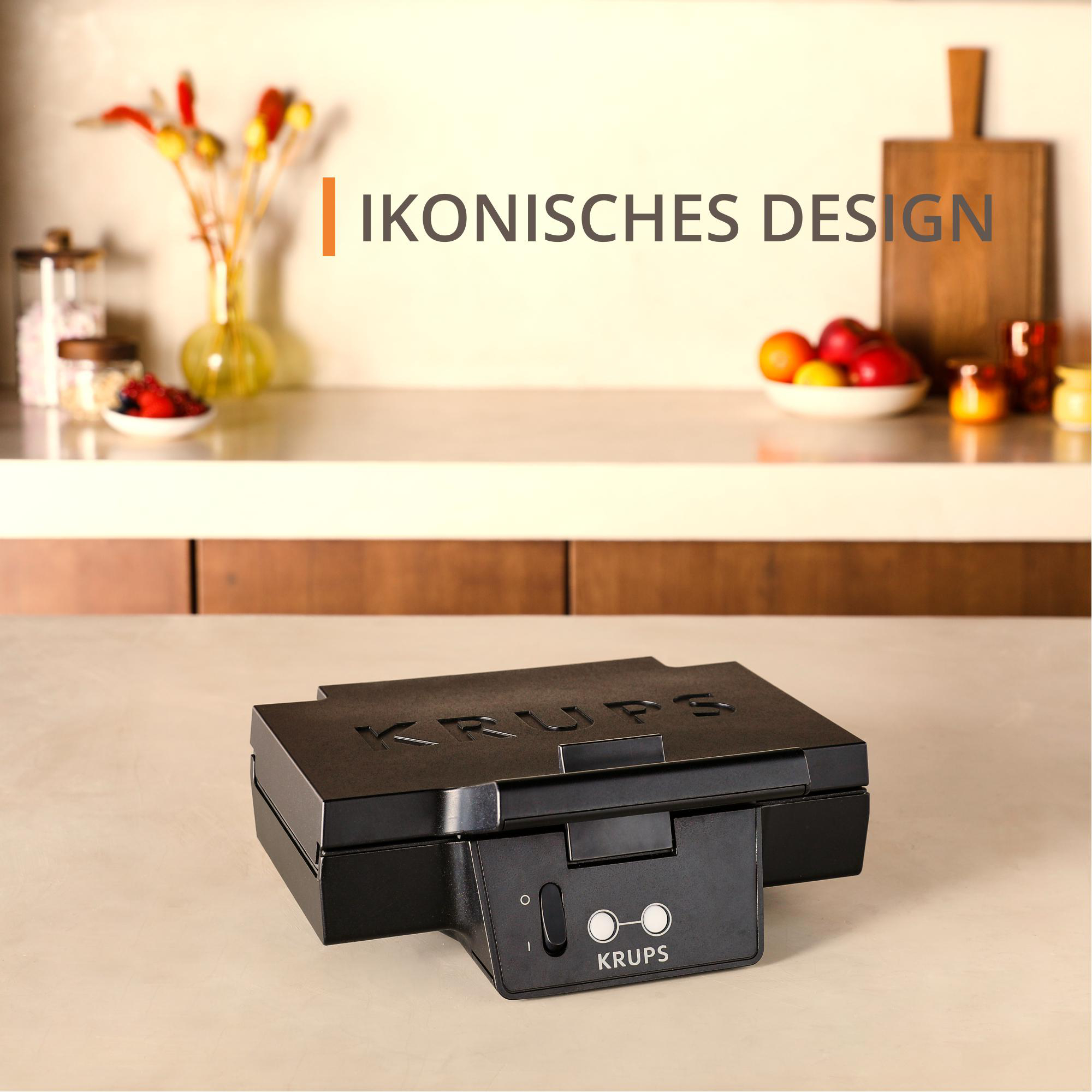 Ein schwarzes Waffeleisen mit rundem Einschaltknopf und KRUPS-Logo auf weißer Arbeitsplatte.