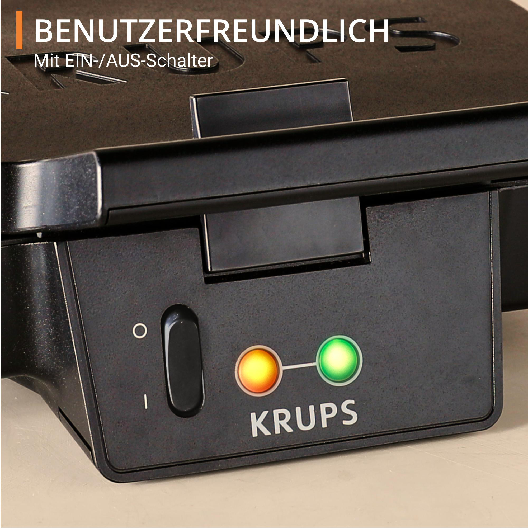 Nahaufnahme des Bedienfelds eines Krups Waffeleisens mit Ein-/Ausschalter und Kontrollleuchten.