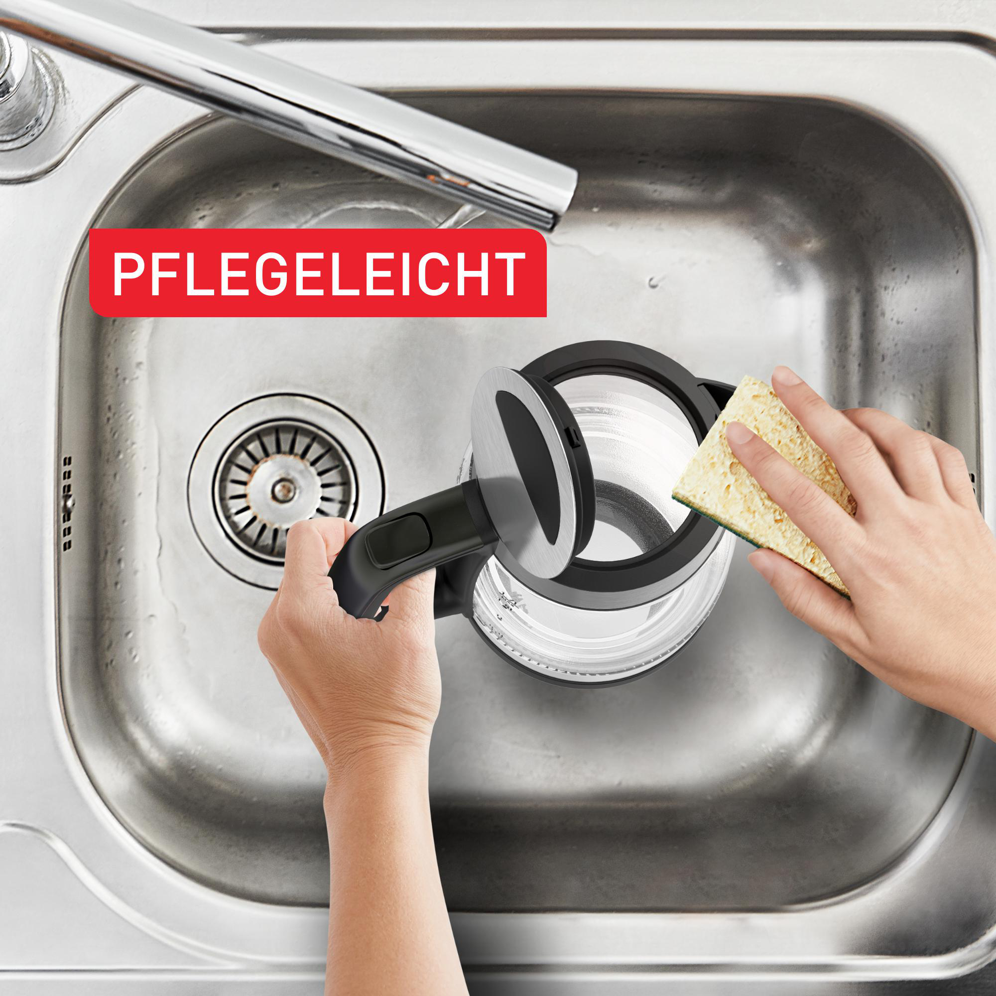 Ein schwarzer Wasserkocher mit offenem Deckel, der mit einem Schwamm in einem Edelstahlbecken gereinigt wird.