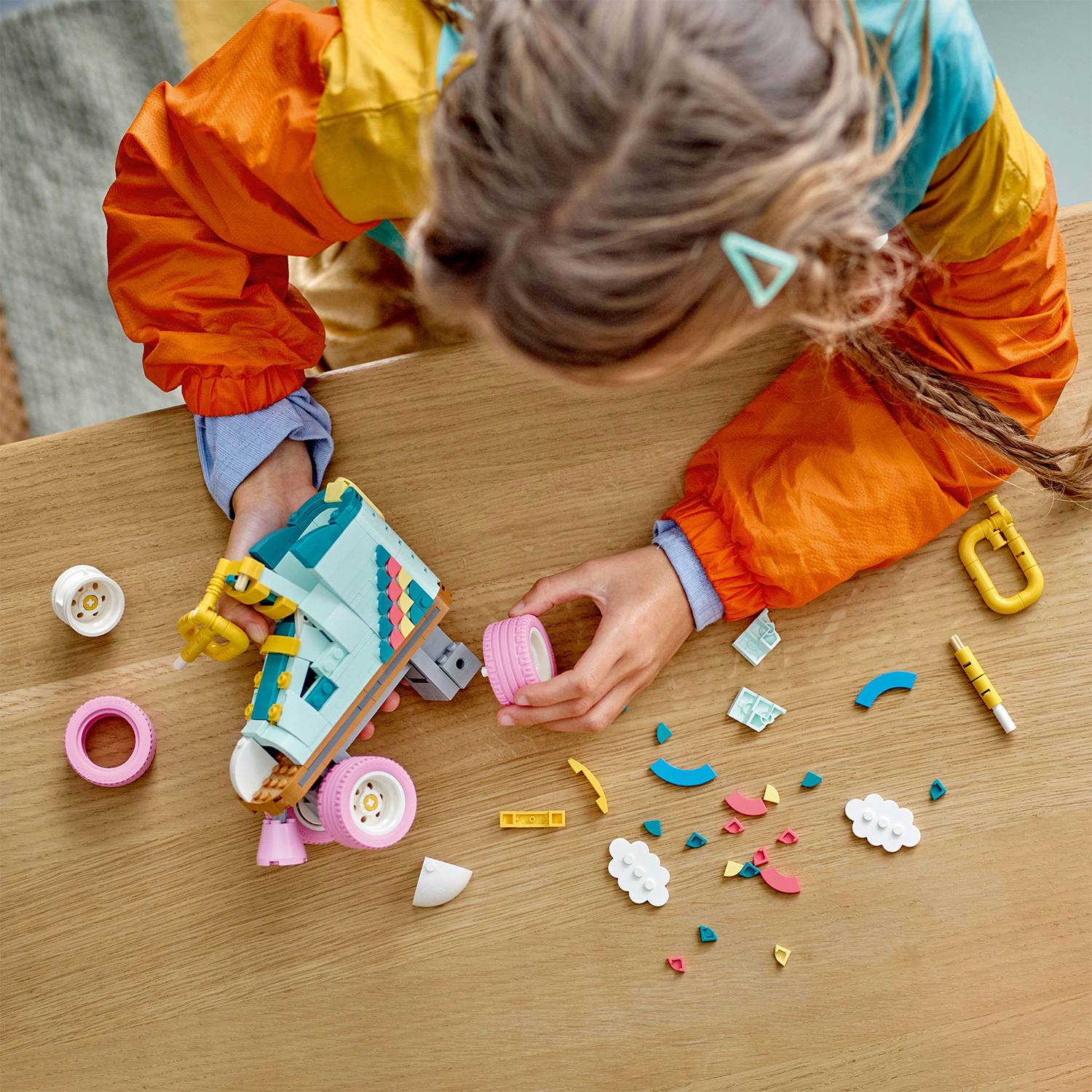 Un bambino che assembla pezzi di un giocattolo LEGO su un tavolo di legno, con toni rosa e blu.