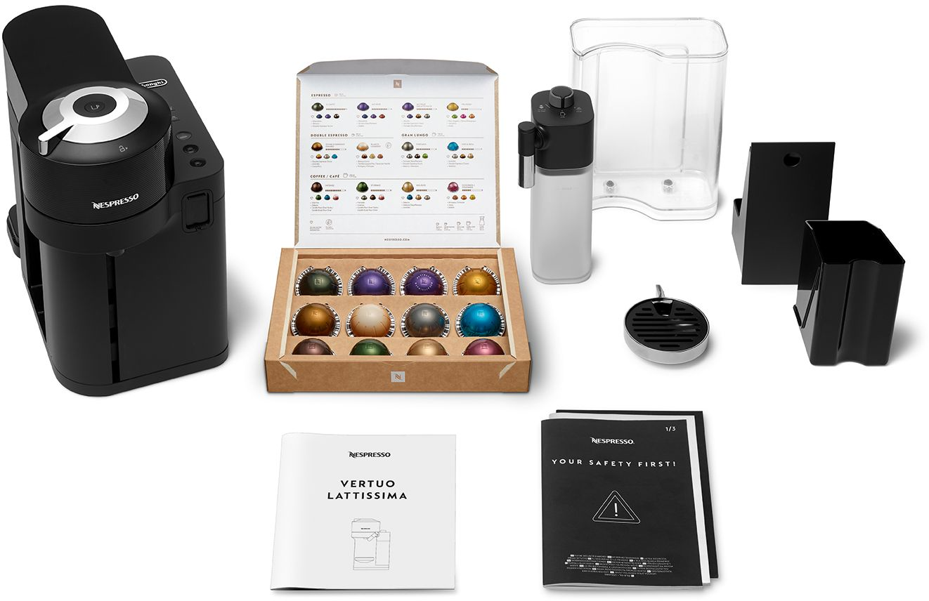 Eine Nespresso Vertuo Lattissima Maschine mit Kaffeekapseln, Zubehör und Handbüchern, alles auf weißem Hintergrund.