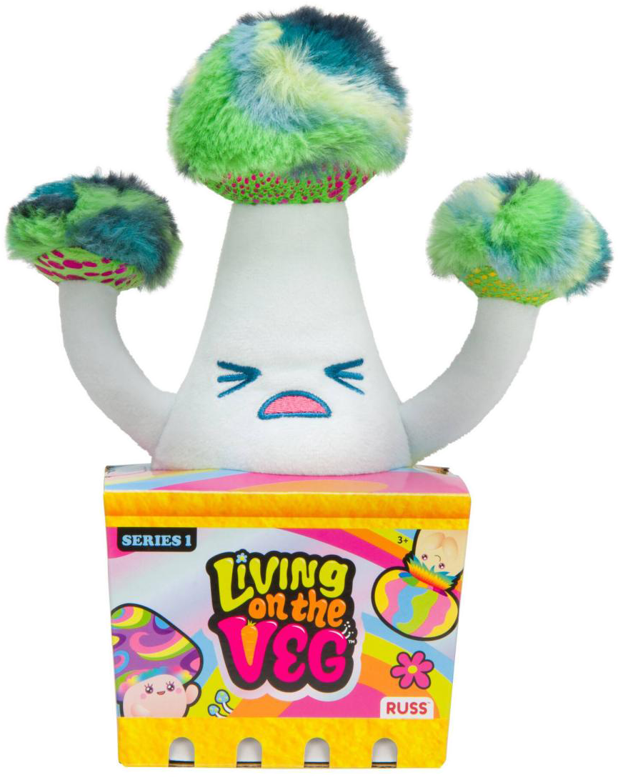 Egy fehér gombajáték színes tetővel, egy dobozon ülve, rajta a 'Living on the Veg' felirattal.
