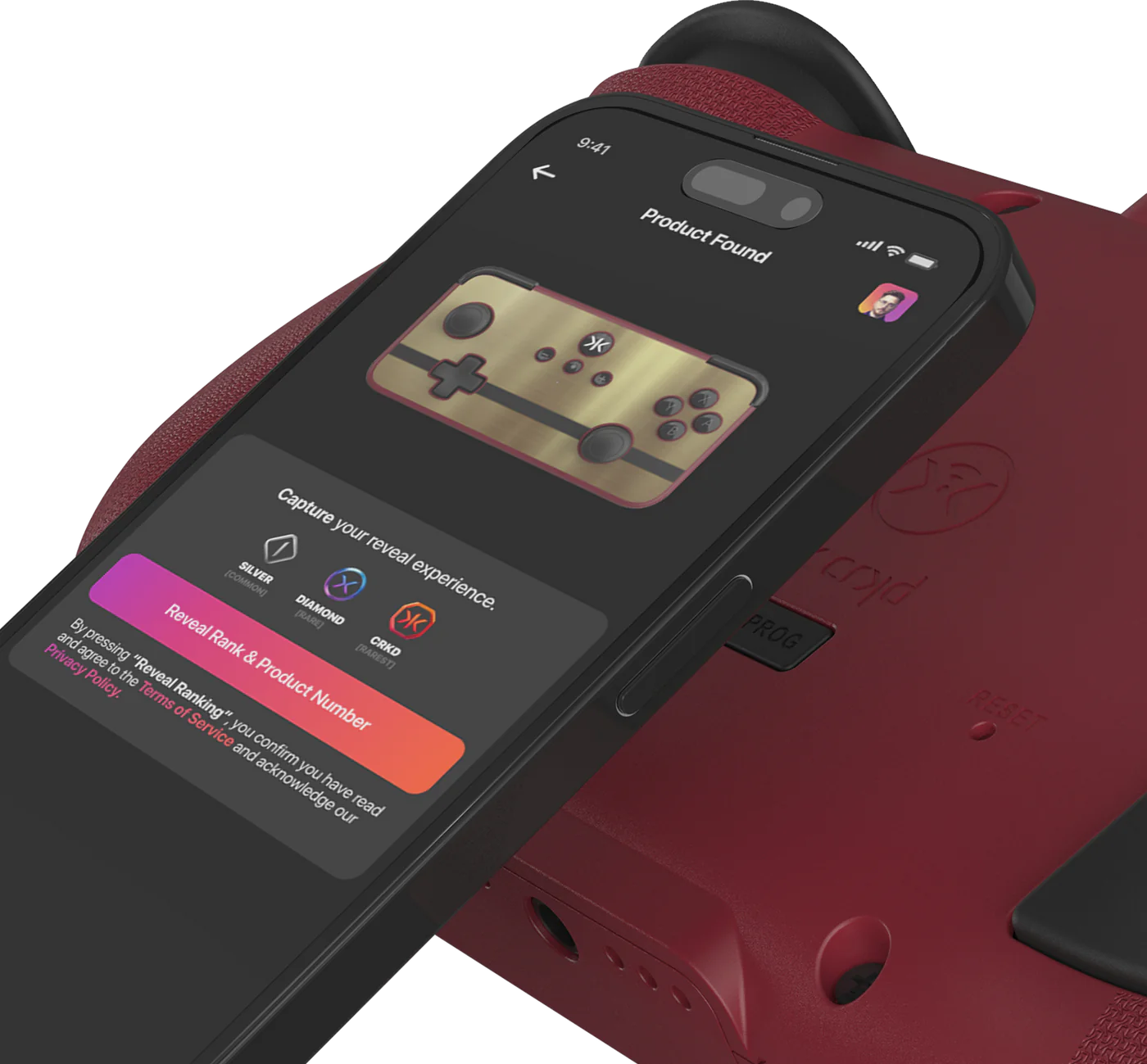 Un telefono mostra un design di controller dorato con un controller rosso e un dispositivo di gioco sullo sfondo.