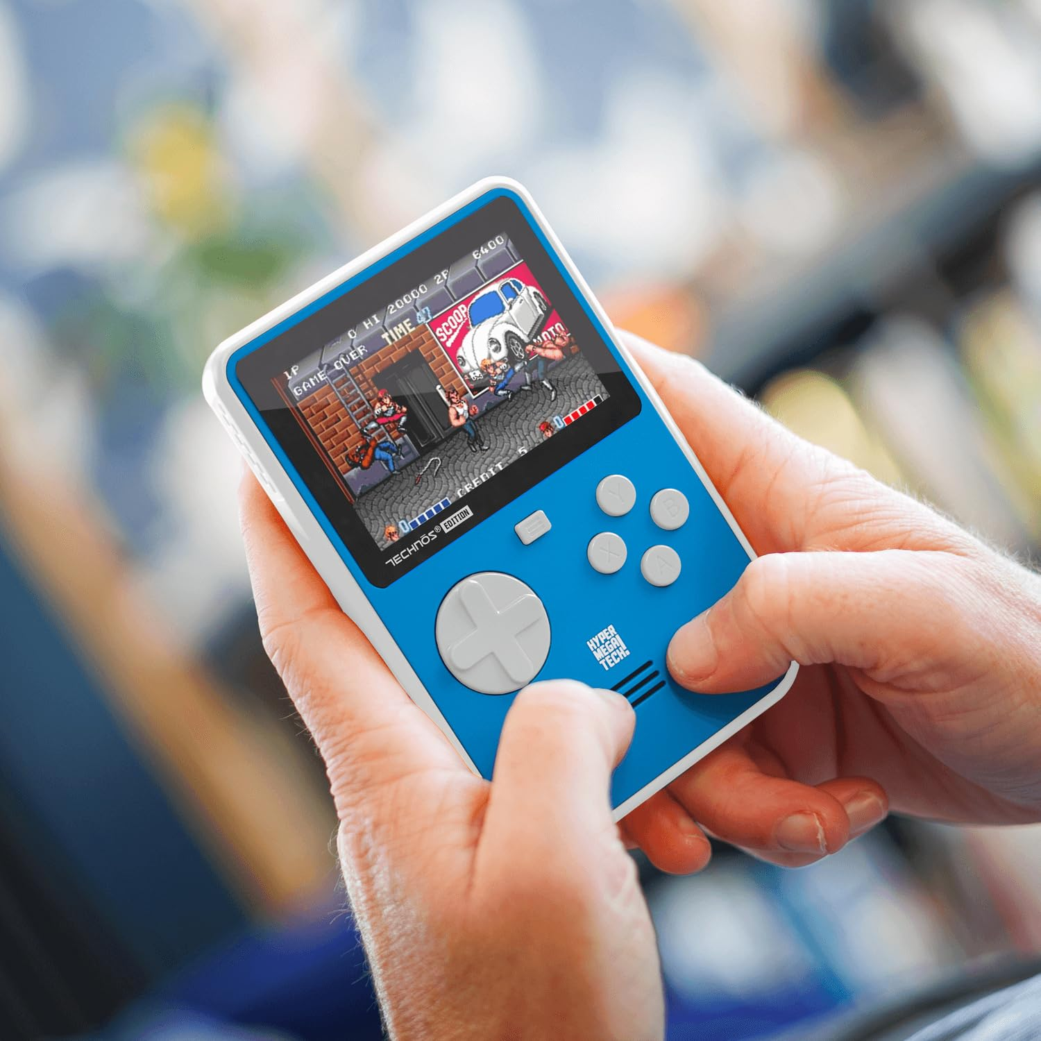 Une console de jeu portable avec un écran affichant un jeu pixélisé. Des mains tiennent l'appareil.