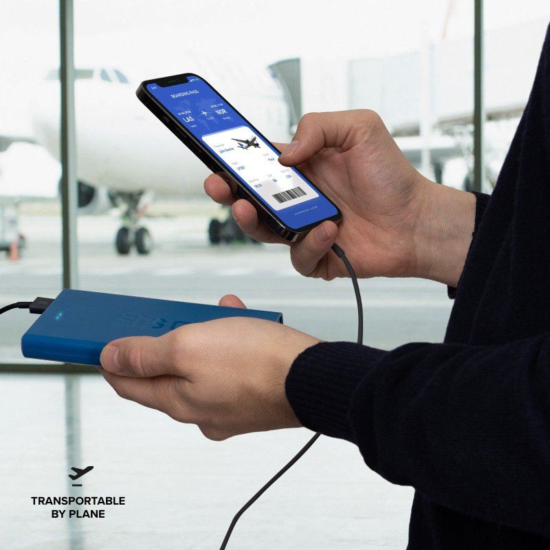 Person hält Telefon mit Bordkarte, verbunden mit einer blauen Powerbank.