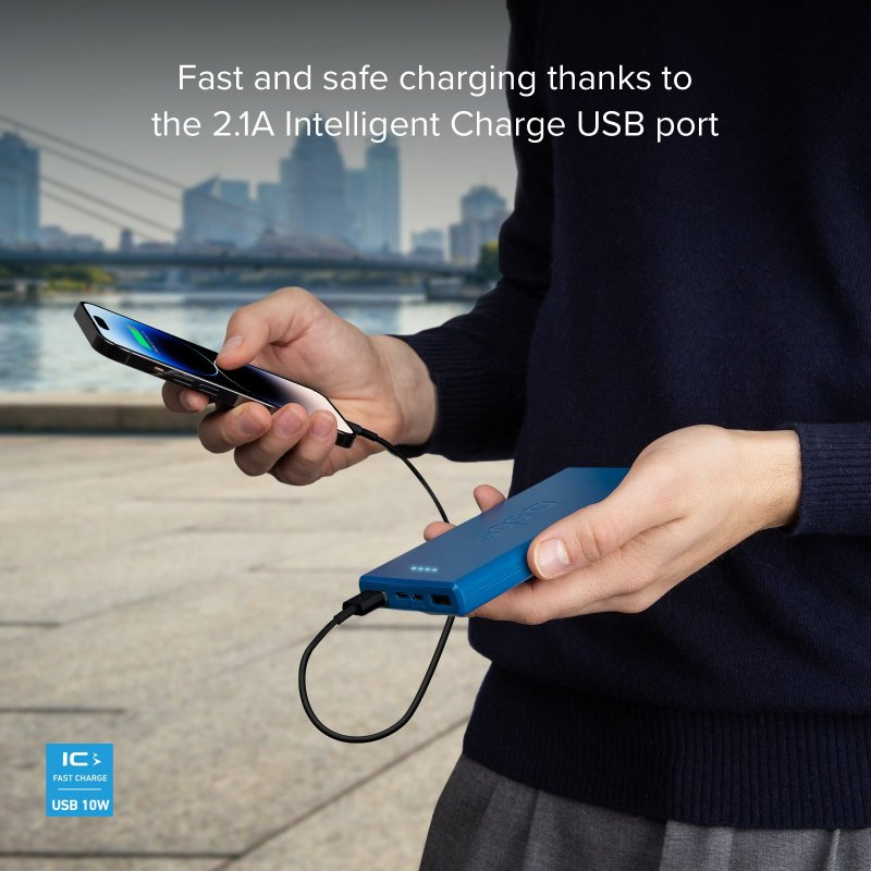 Eine Person, die ein Telefon und eine blaue Powerbank hält, die durch ein schwarzes Kabel verbunden sind, mit Stadt im Hintergrund.