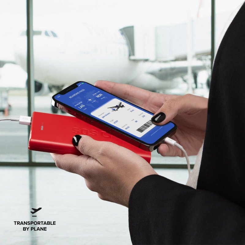 Person hält Telefon mit Bordkarte, verbunden mit einer roten Powerbank.