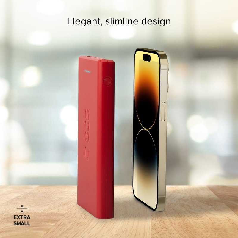 Rote Powerbank und Smartphone nebeneinander auf einer Holzoberfläche.