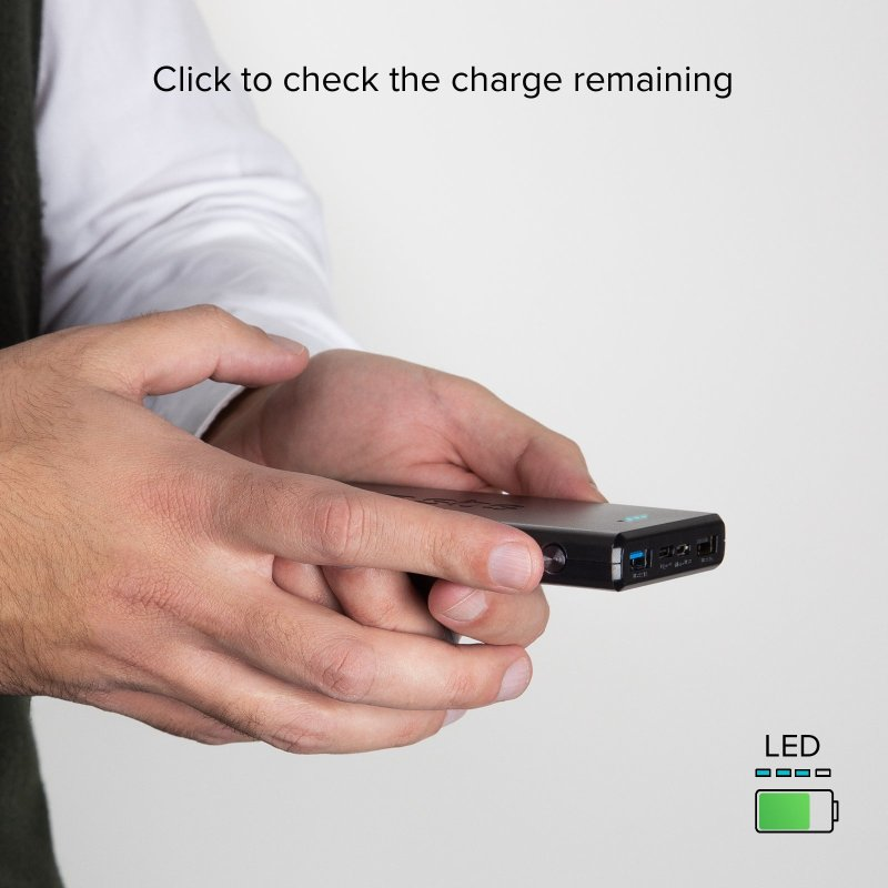 Hände halten eine schwarze Powerbank, mit LED-Batterieanzeige und Text.