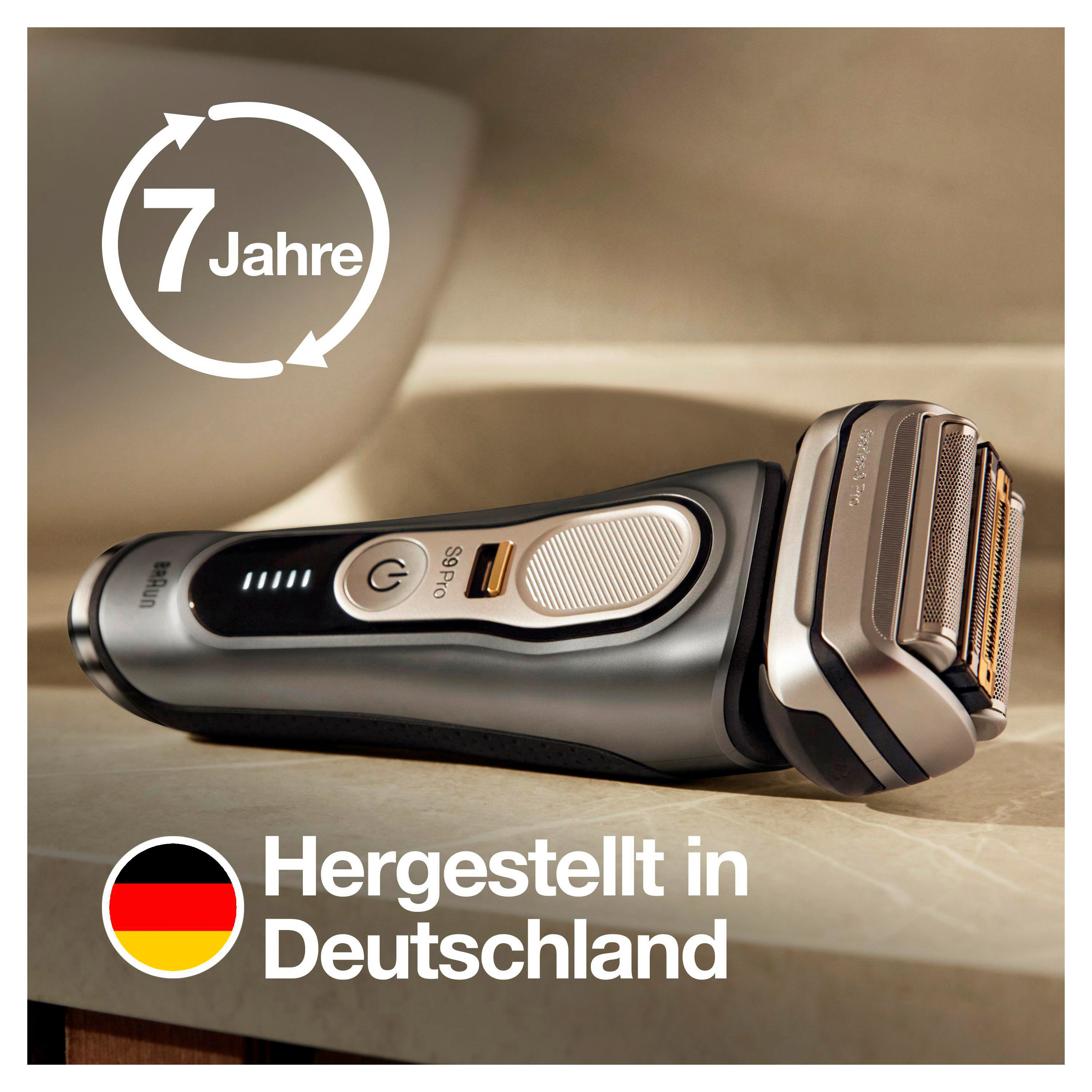 Ein silberner und schwarzer Elektrorasierer mit dem Text 'Hergestellt in Deutschland' auf einer Oberfläche.