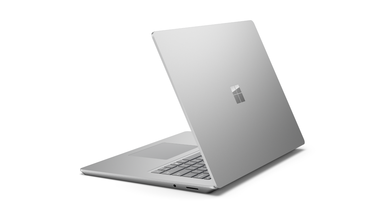 Portátil Microsoft Surface plateado sobre fondo negro. La tapa está abierta.