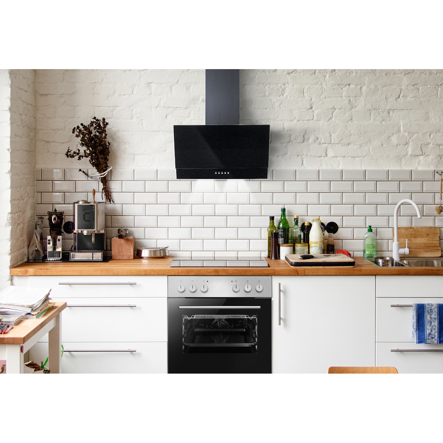 Keukeninterieur met oven en fornuis, afzuigkap en witte kasten, houten aanrechtblad.