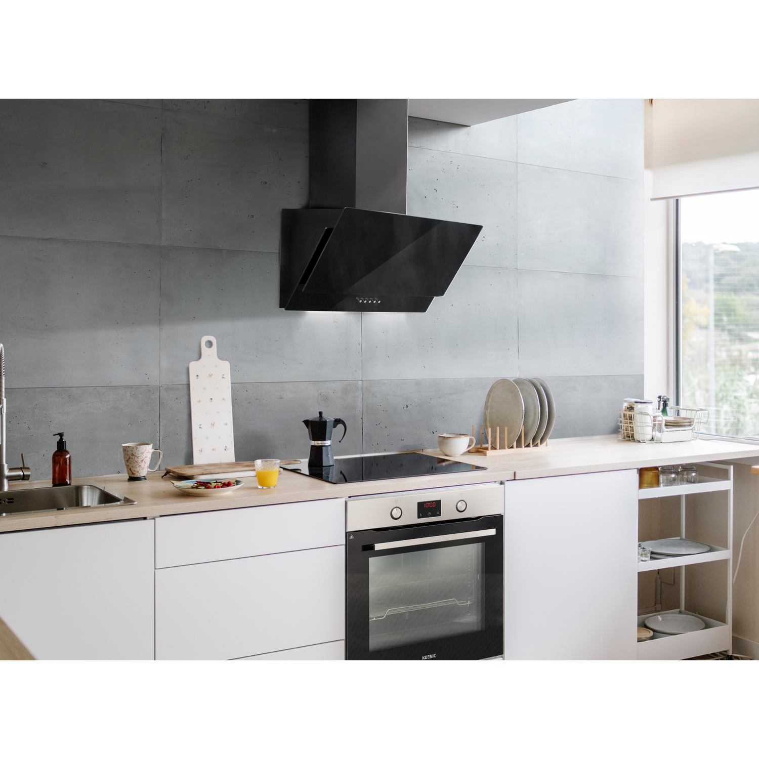 Een moderne keuken met een zwarte afzuigkap. Er is een fornuis, een oven en een aanrecht met items.