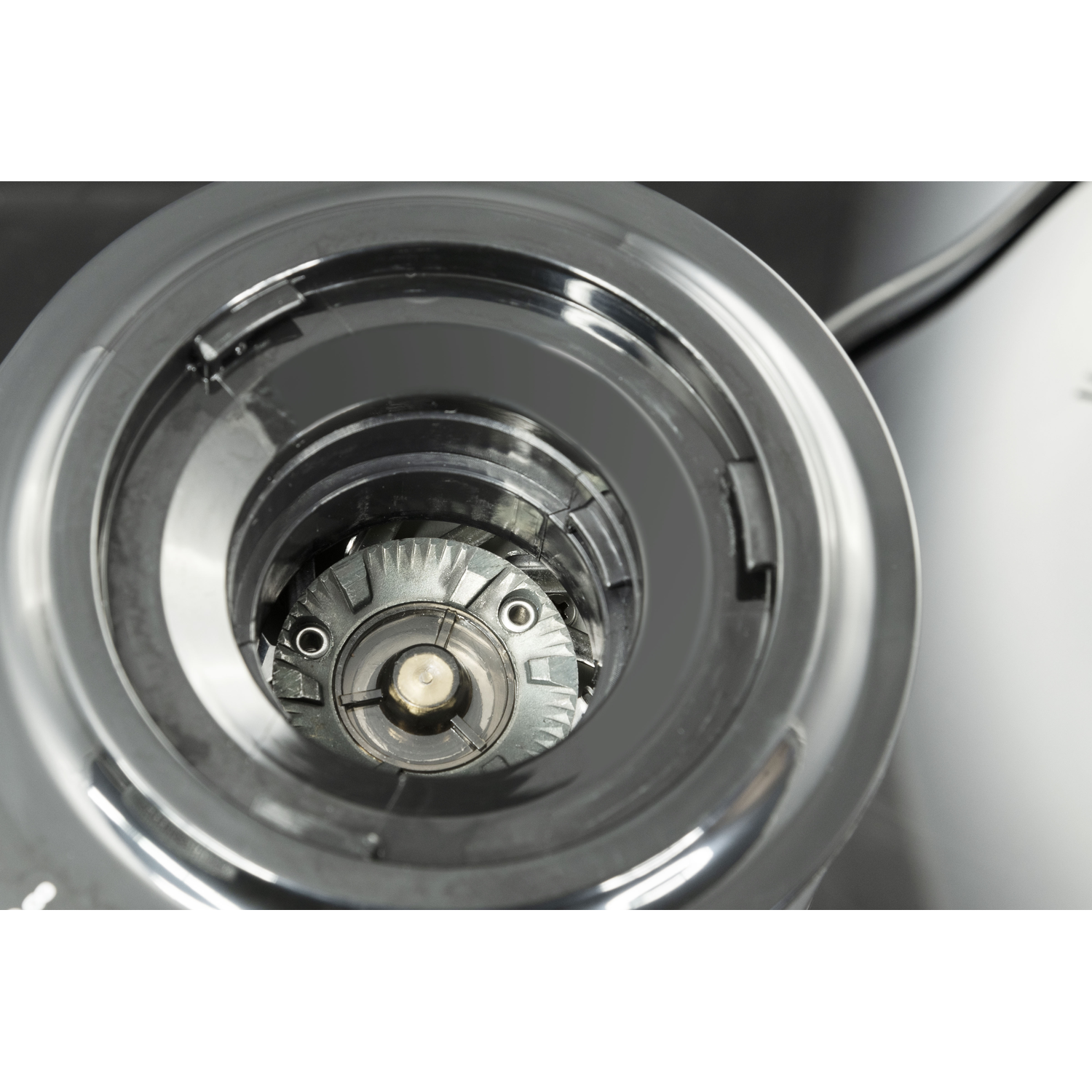 Close up of a dark grey grinder with visible internal mechanism.