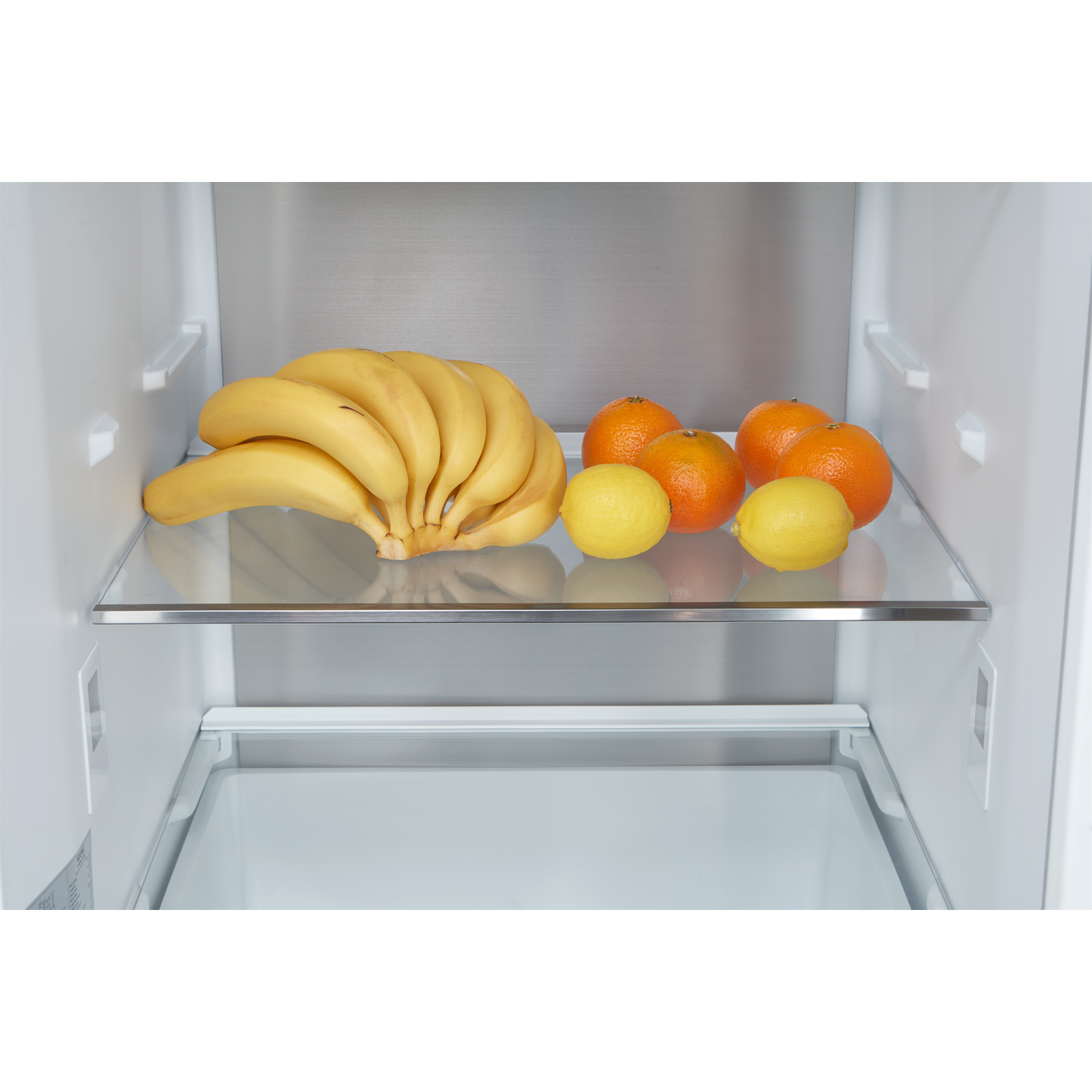 Refrigerator shelf with bananas, oranges, and lemons.