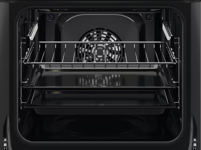 Widok wnętrza piekarnika. Pokazuje ruszty, wentylator i ciemne wnętrze urządzenia.