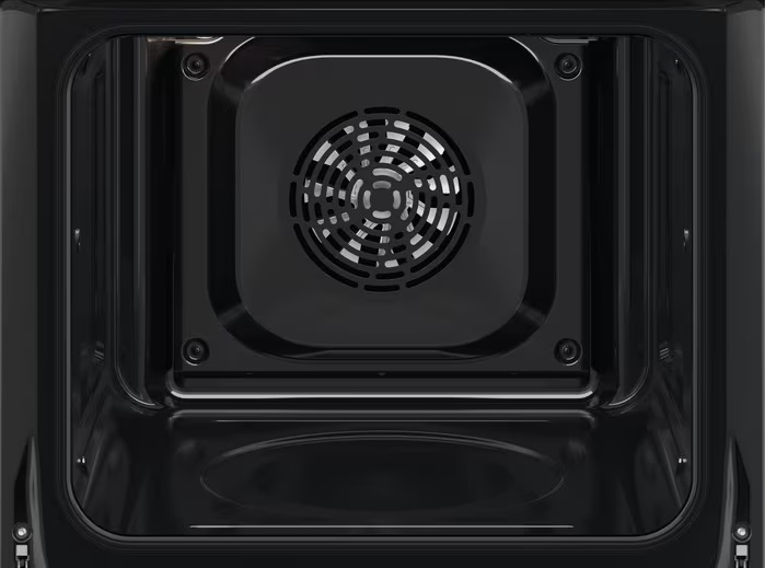 Otwarty wnętrze piekarnika z widocznym wentylatorem i elementami grilla, ciemne wnętrze.