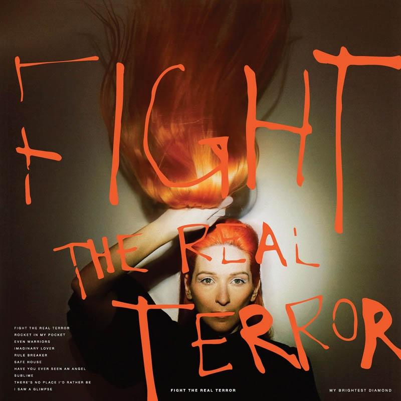 Albumcover mit einer Frau mit orangefarbenem Haar und den Worten "FIGHT THE REAL TERROR" in großen Buchstaben.
