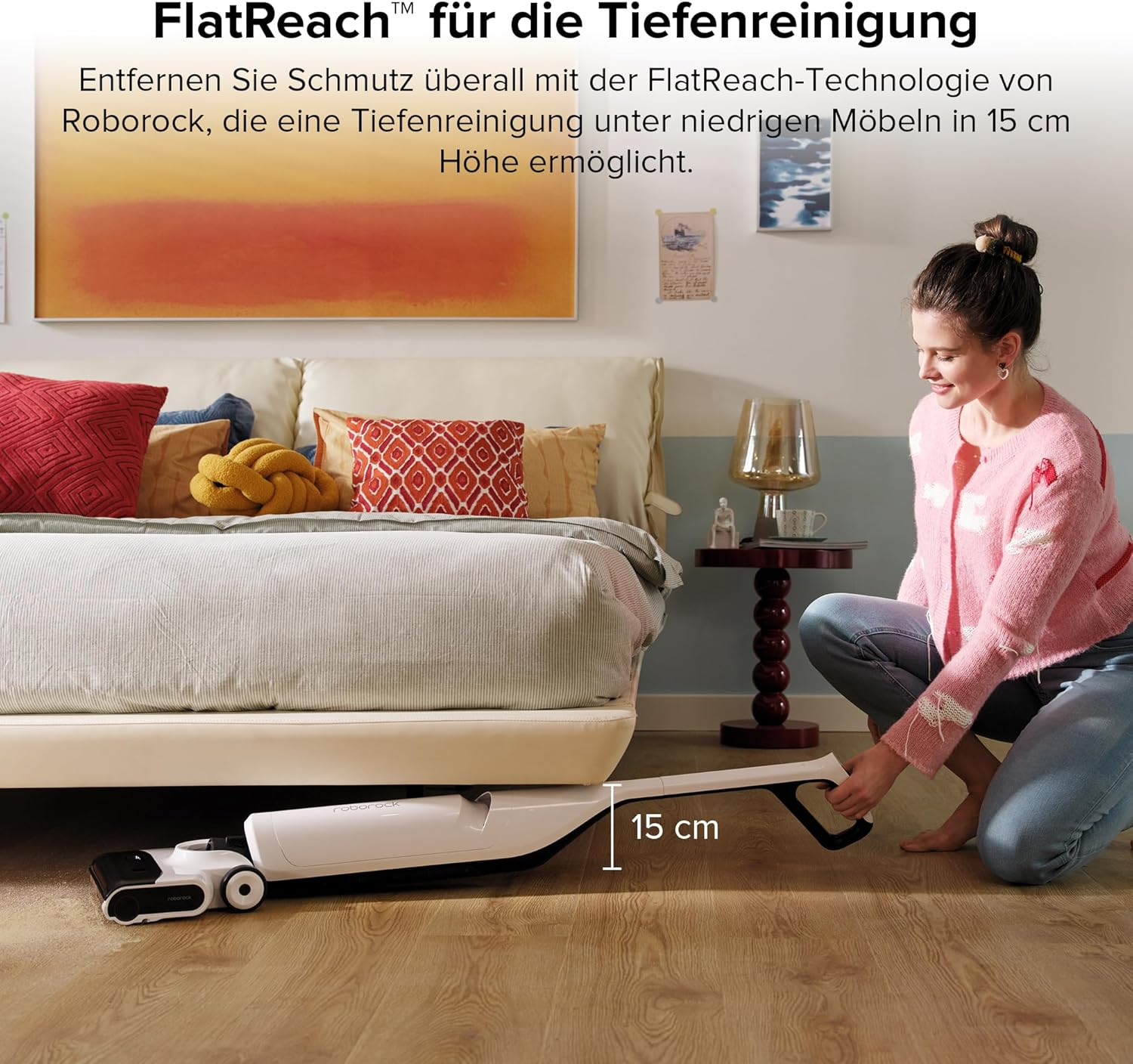 Femme passant l'aspirateur sous un lit avec un aspirateur blanc et noir.