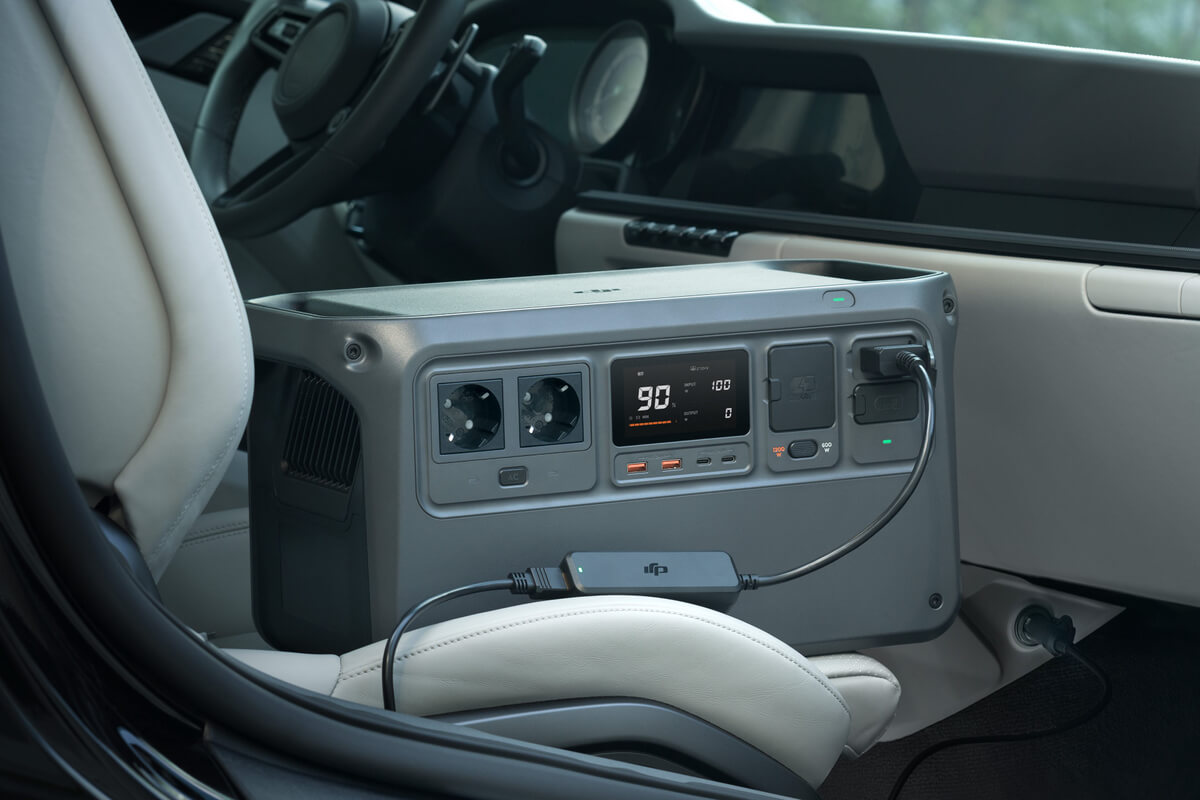 Przenośna stacja zasilania w samochodzie. Ma wiele gniazd i wyświetlacz.