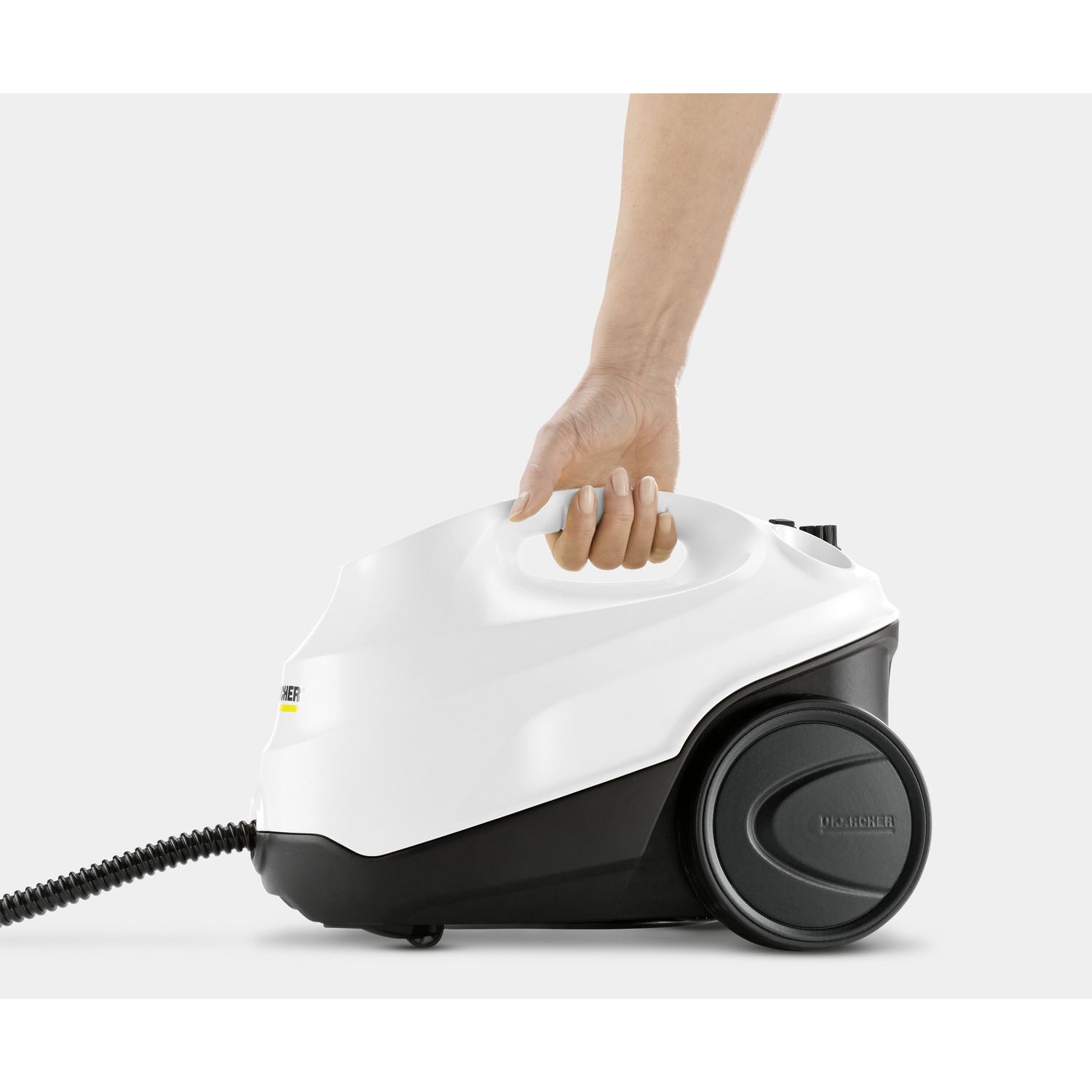 A person's hand holding a white and black steam cleaner with a black wheel.