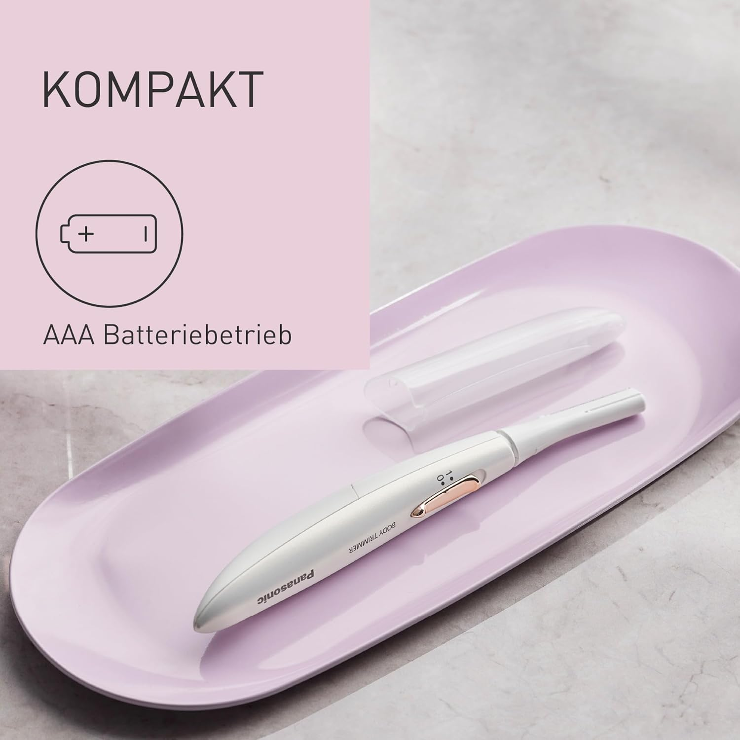 Un rasoir corporel Panasonic blanc sur un plateau rose, avec une icône de batterie et le mot 'Kompakt'.