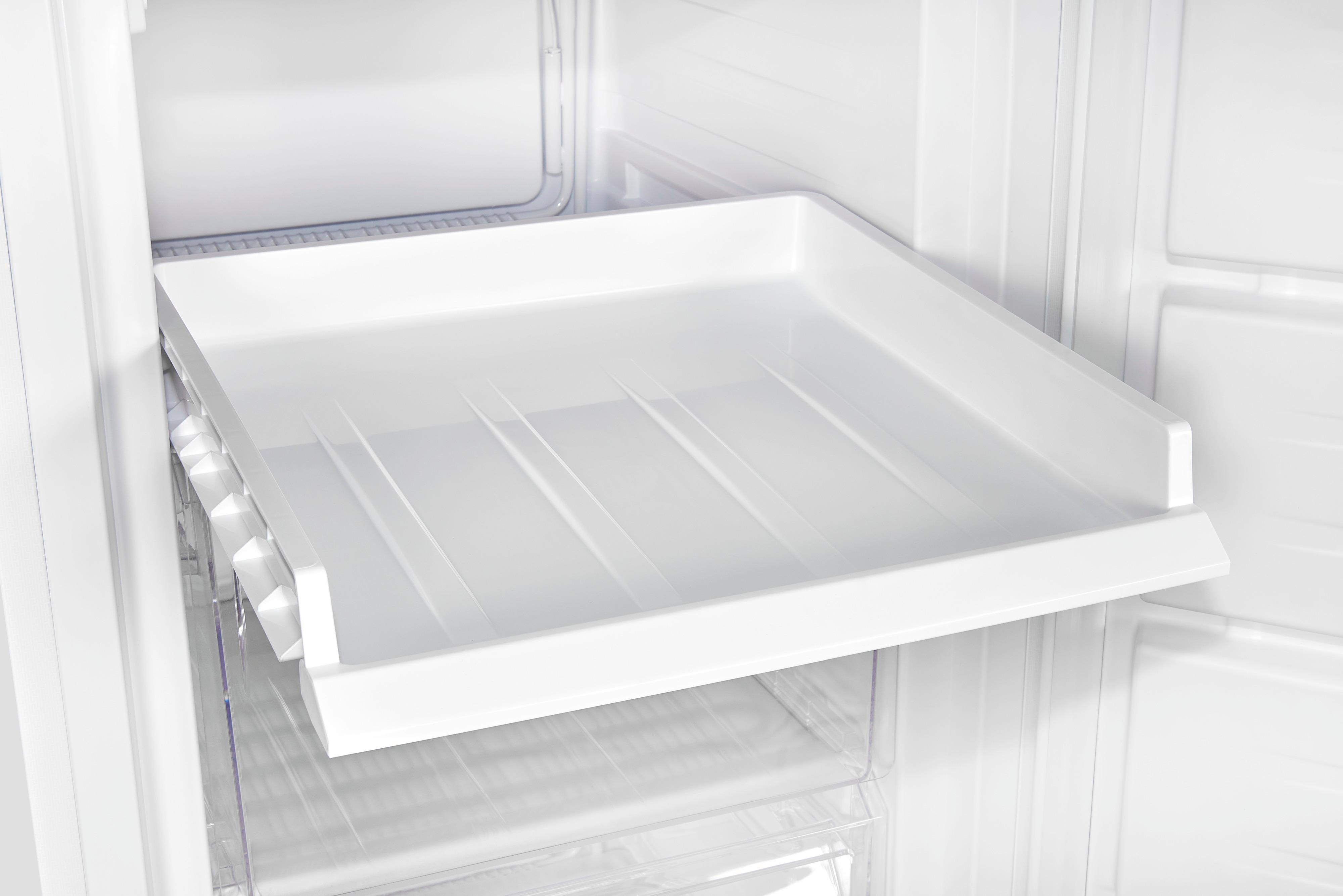 Im Inneren eines Kühlschranks, ein weißes Regal wird aus dem Kühlschrank gezogen.