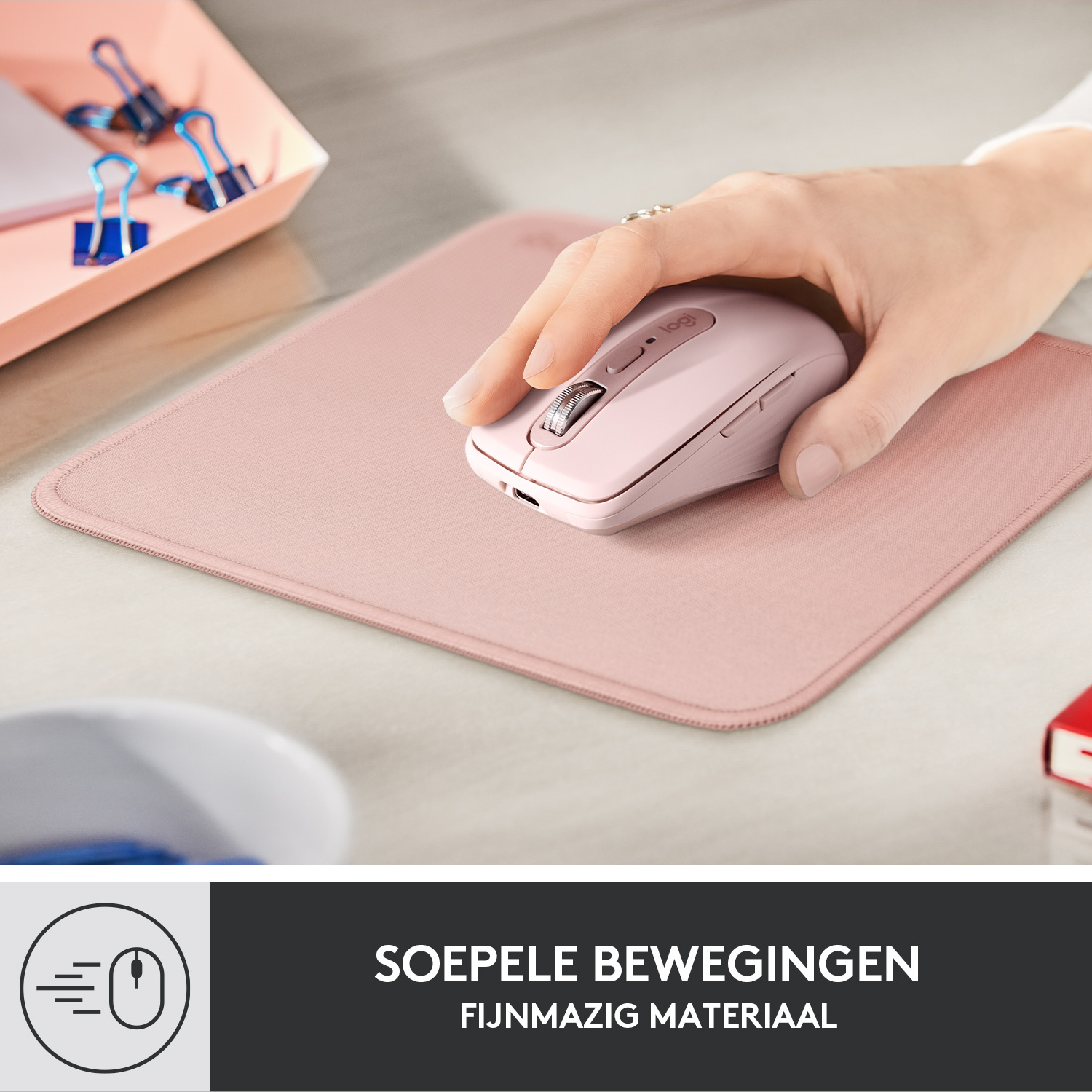 Hand van persoon die een roze Logitech-muis gebruikt op een roze muismat. Witte bureau, andere objecten.