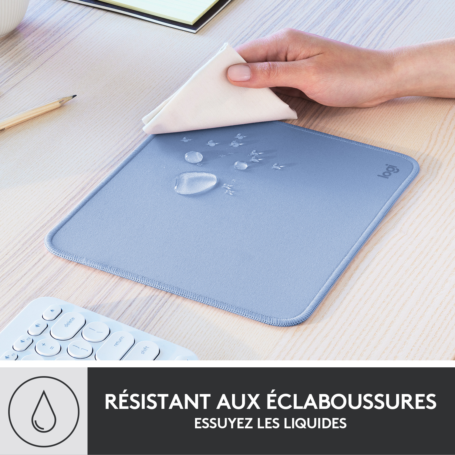 Tapis de souris bleu clair avec un chiffon blanc essuyant des gouttes d'eau.