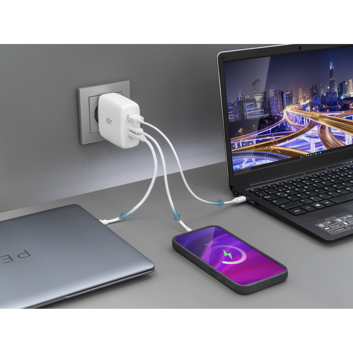 Een laptop, telefoon en oplader aangesloten op een stopcontact.