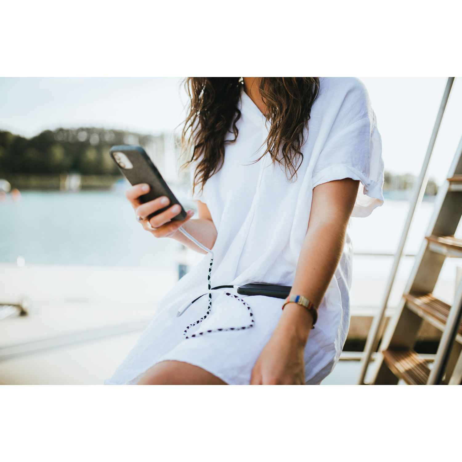 Une femme tenant un smartphone et le regardant.