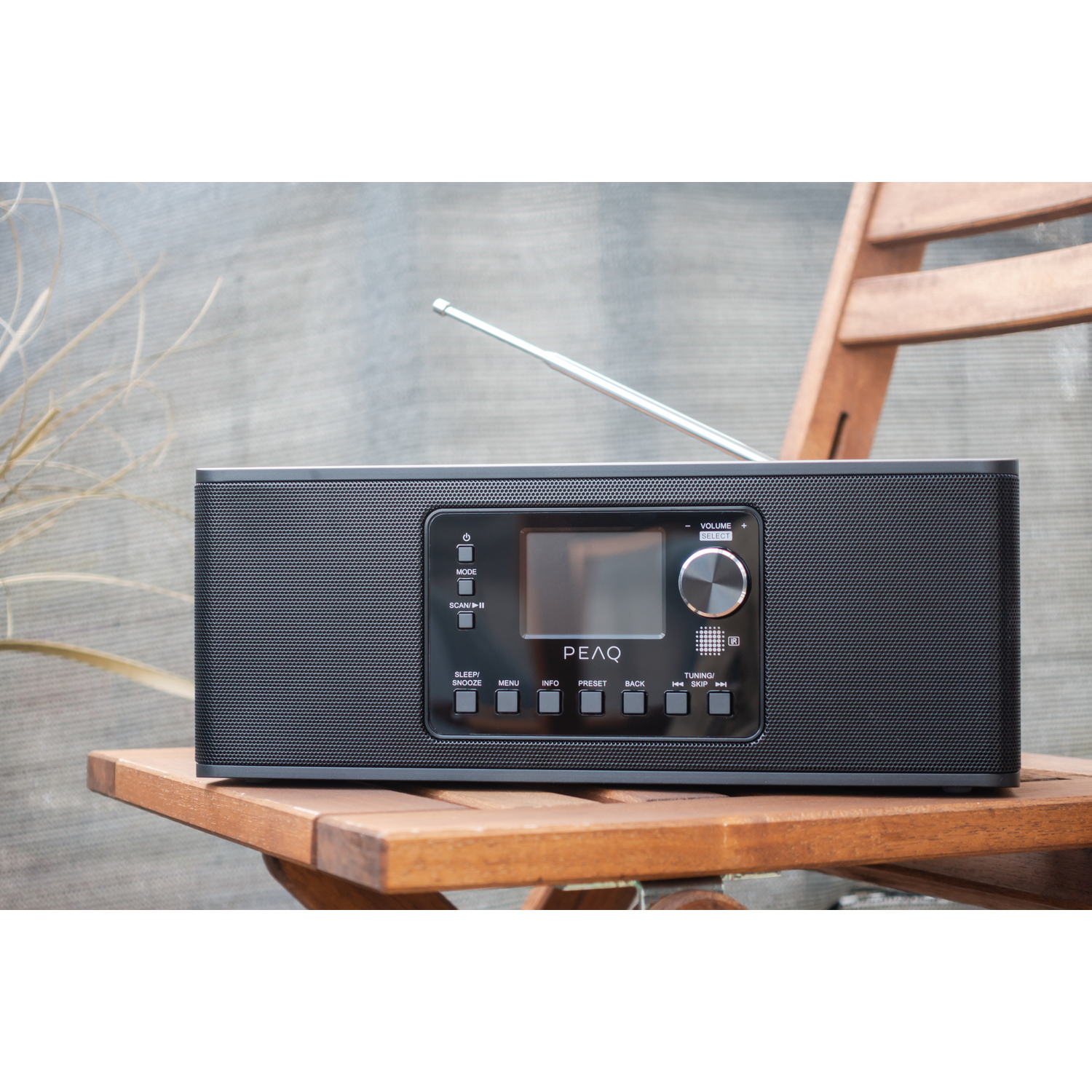 Black radio on a wooden chair, with screen.