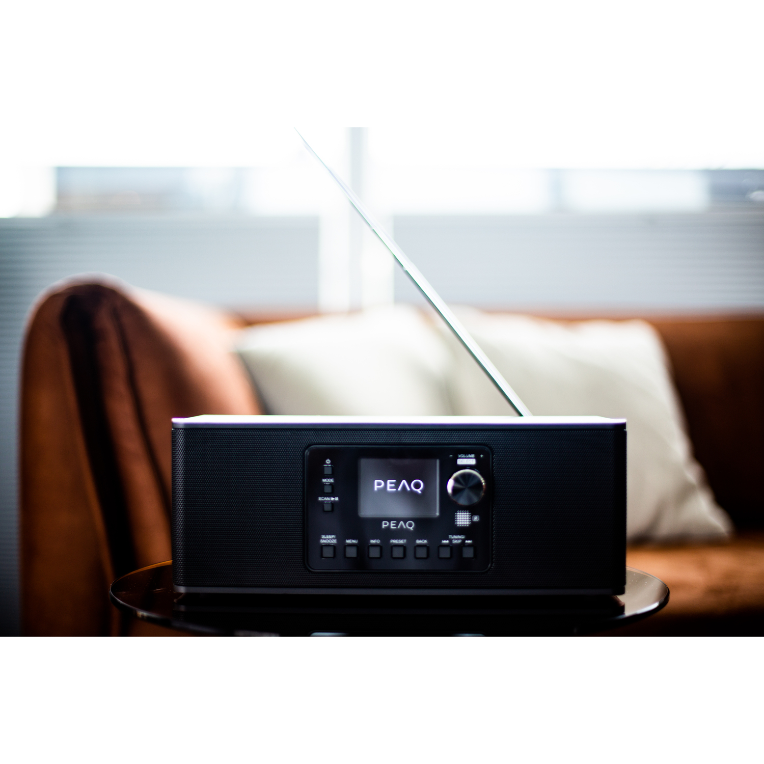 Black and silver PEAQ radio. A screen and control knob are visible.