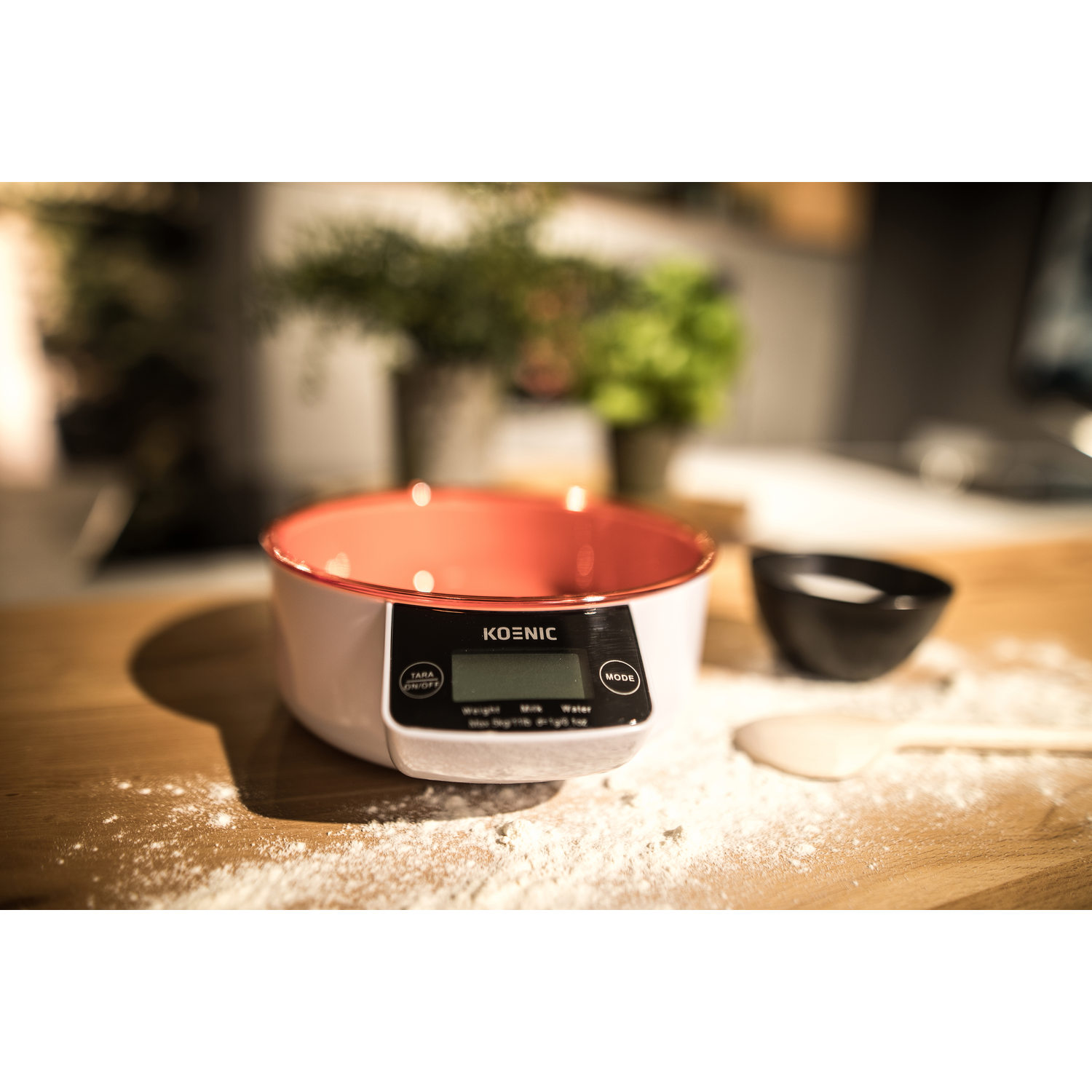 A digital kitchen scale with a red bowl and flour.