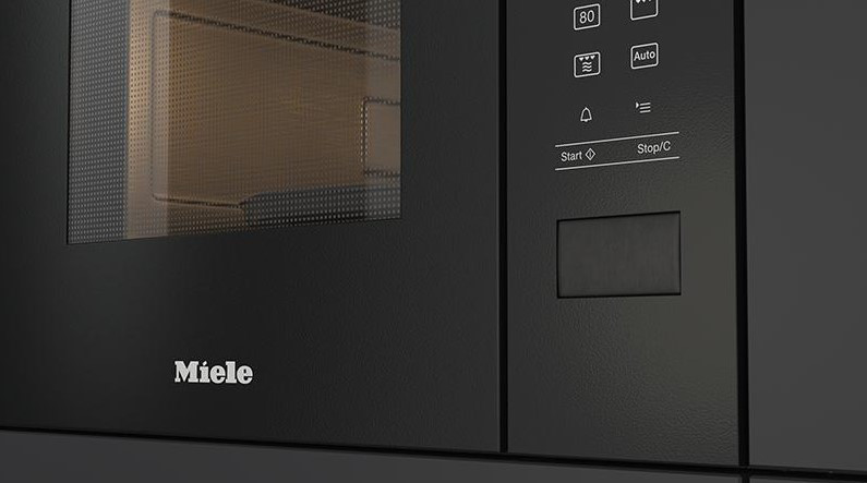 Gros plan d'un four à micro-ondes Miele noir. Le panneau de commande et la porte vitrée sont visibles.
