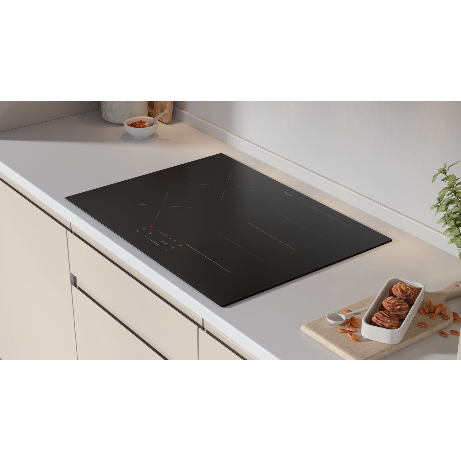 A black cooktop on a white countertop, with a wooden board with nuts in the front.