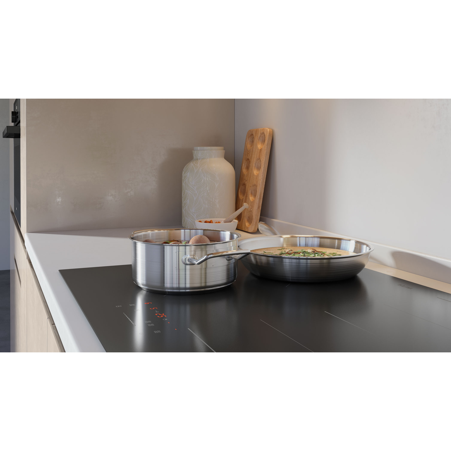 A kitchen counter with a pot and pan on an induction cooktop. A vase and cutting board are visible.