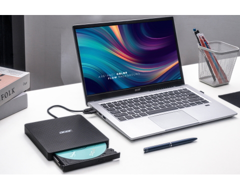 Ein silberner Laptop mit einem Bildschirm, der einen abstrakten, farbenfrohen Hintergrund und ein externes Laufwerk zeigt.