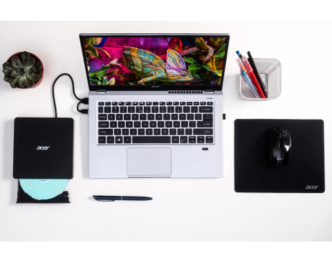 Laptop mit Zubehör auf weißem Schreibtisch. DVD-Laufwerk, Maus, Stift und Pflanze sind vorhanden.