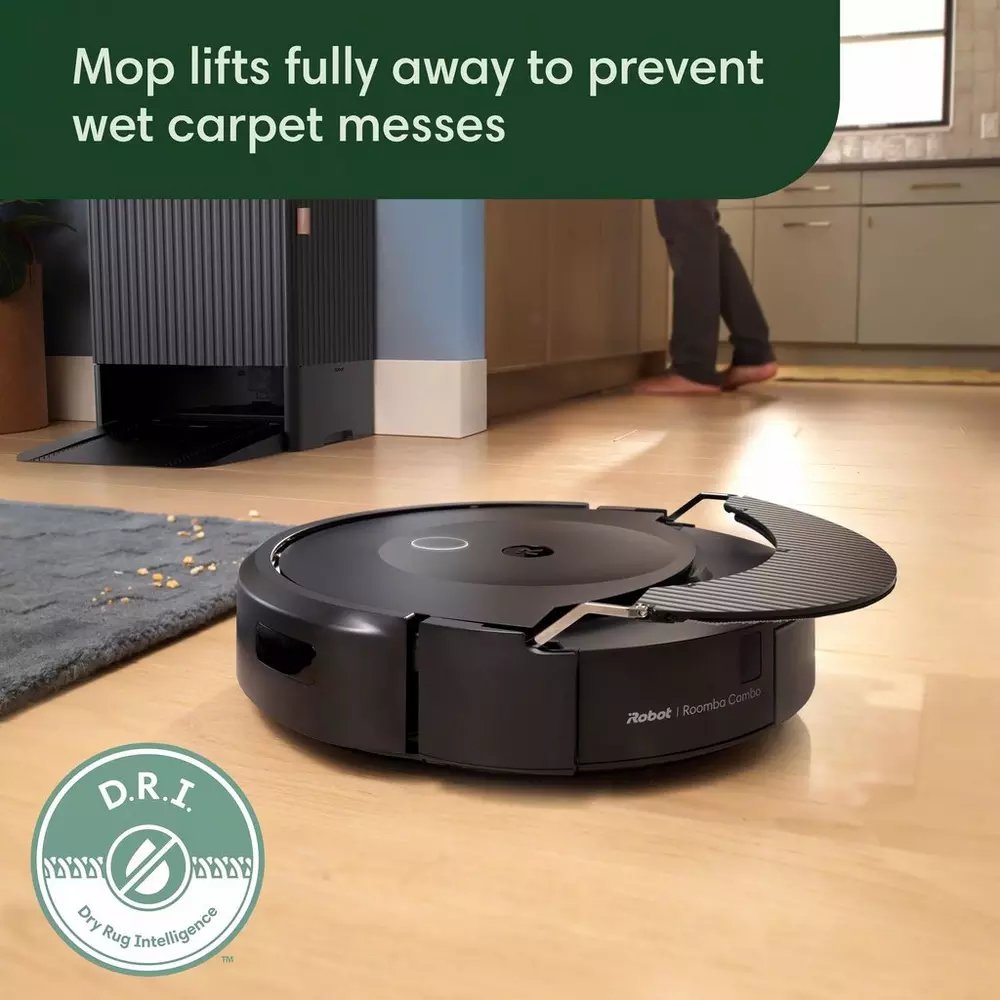 Schwarzer Roboter-Staubsauger reinigt einen Holzboden in einer Küche. Text: Der Mopp hebt sich.