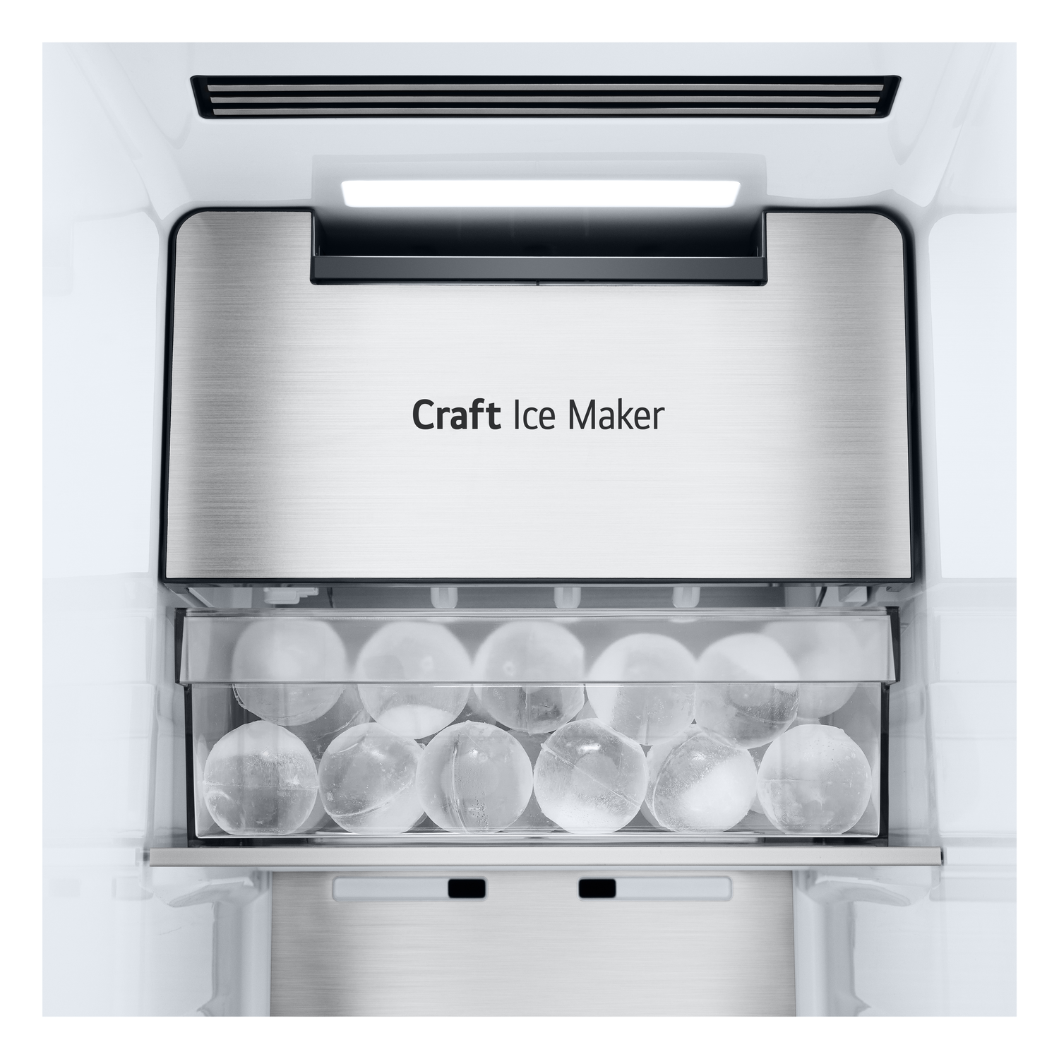 Inside a refrigerator, a 'Craft Ice Maker' is above a container of clear, round ice balls.