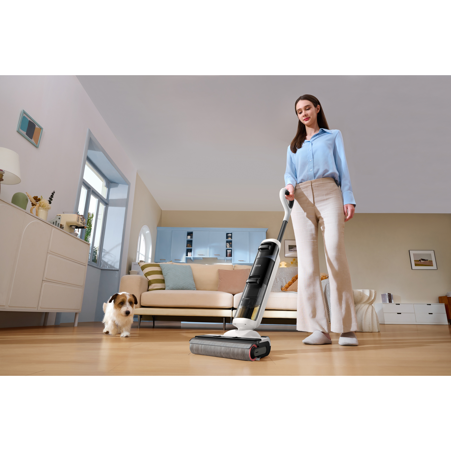 Een vrouw die een stofzuiger gebruikt in een woonkamer met een hond.