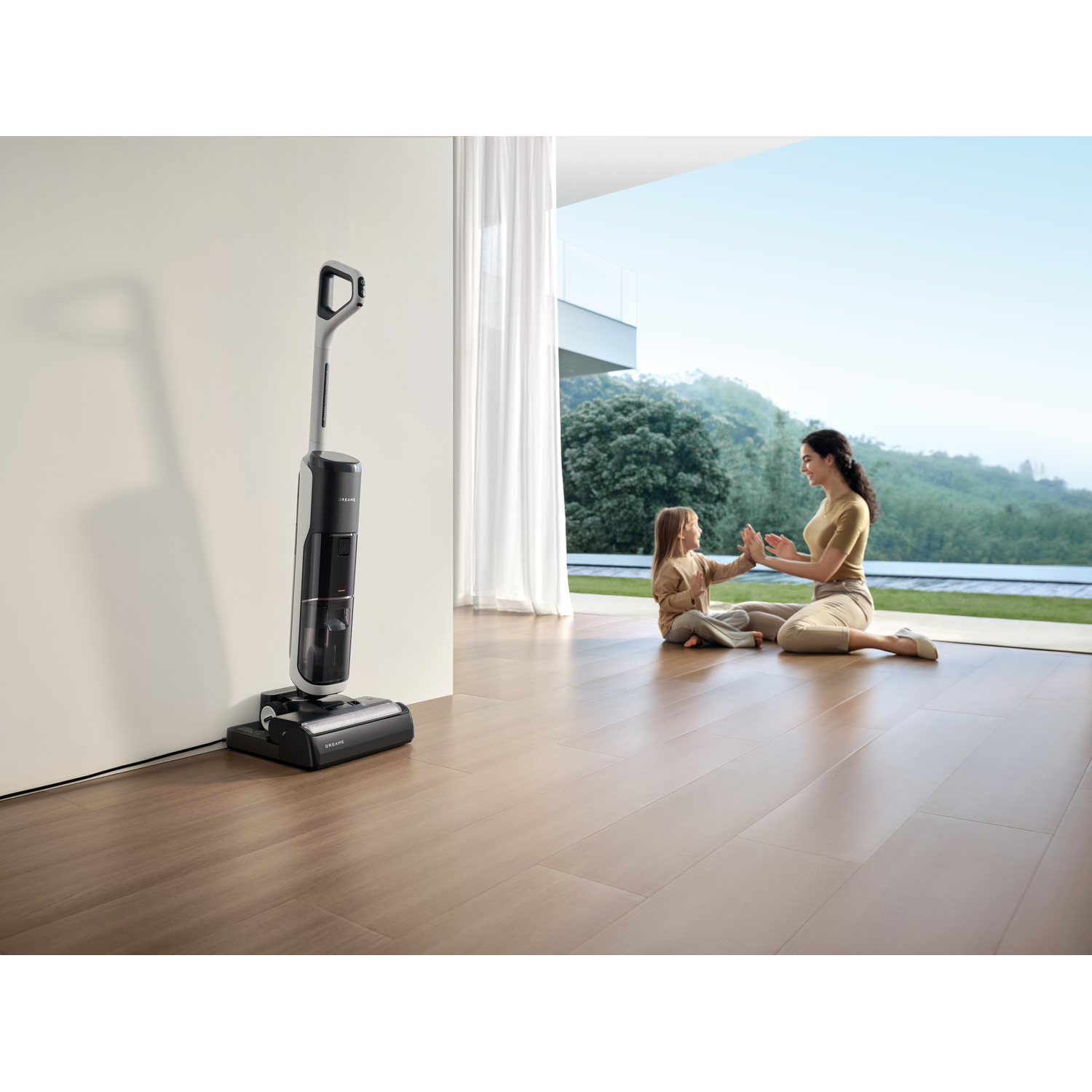 A woman and child are playing together, with a vacuum cleaner nearby.